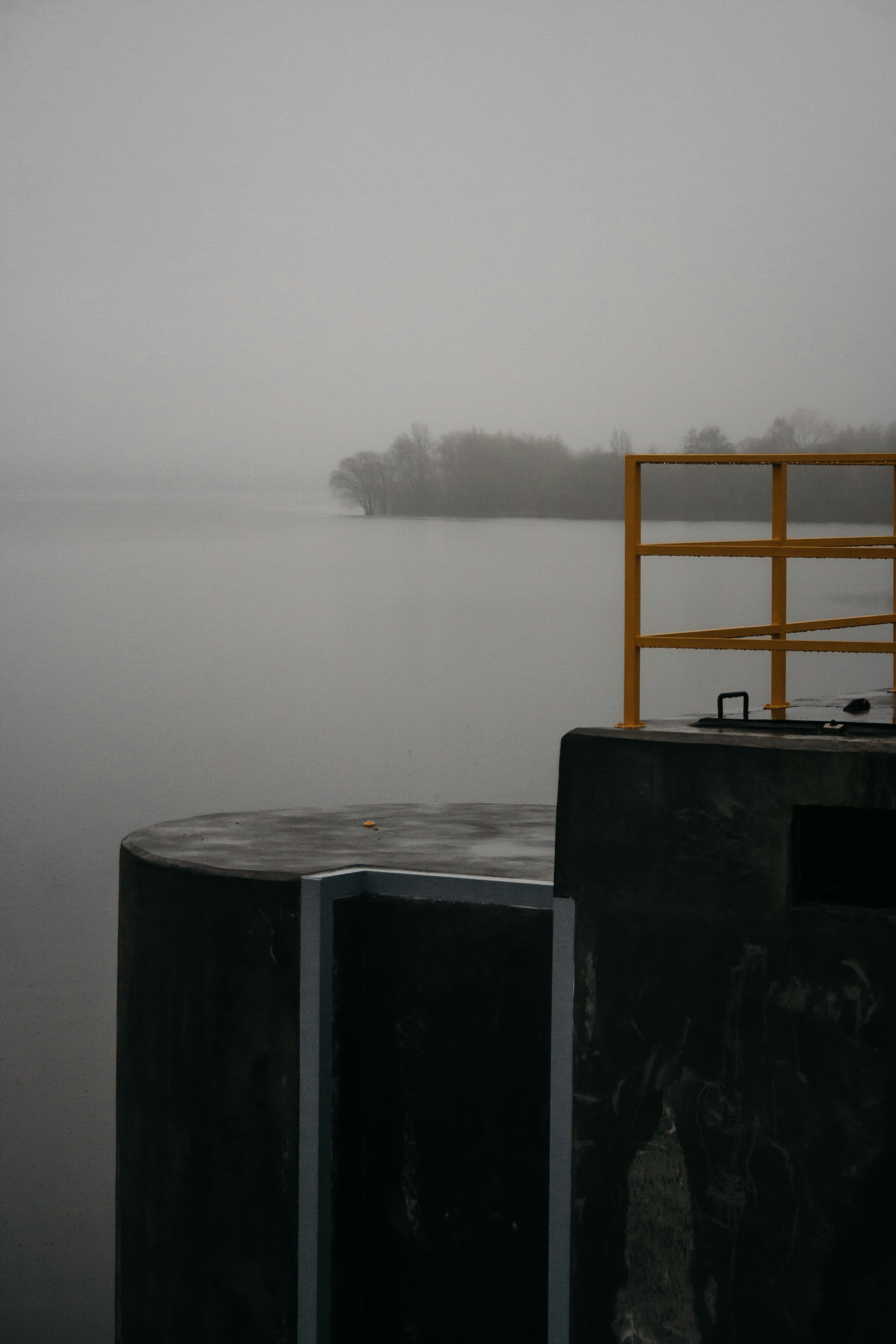 A foggy day on a lake with a boat in the distance