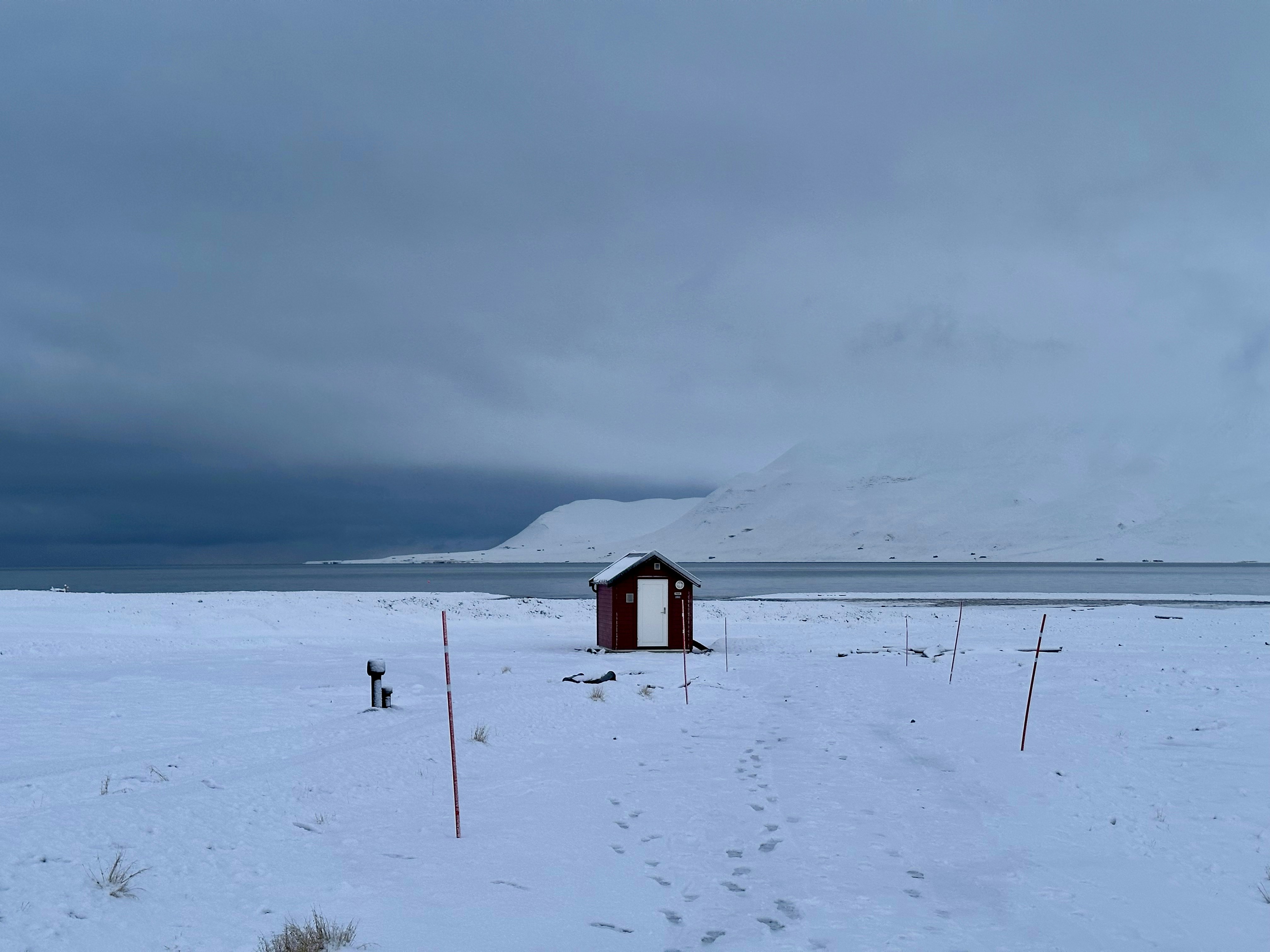 A small hut in the middle of a snowy field