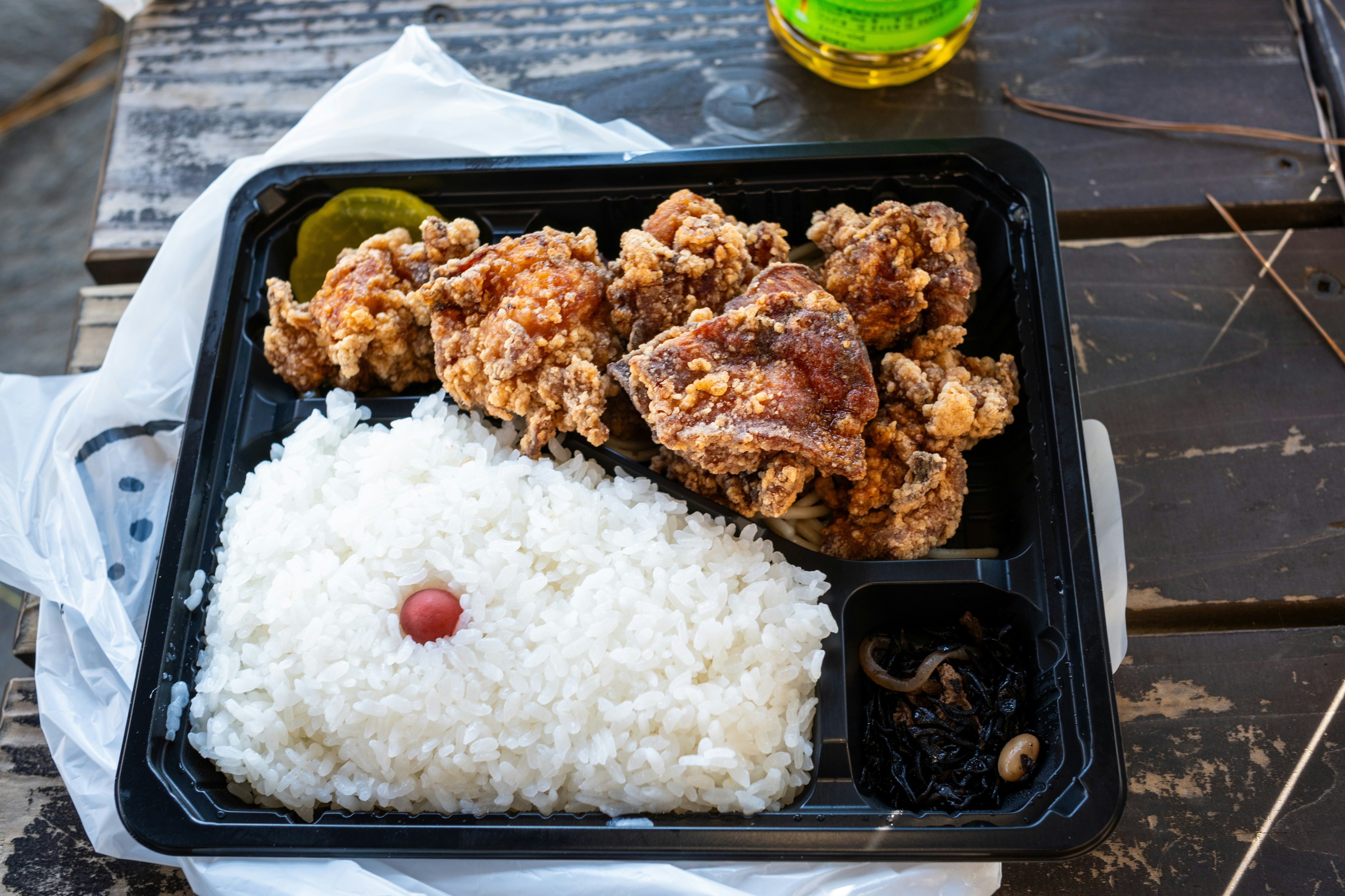 Kotak makan hitam berisi nasi putih dan ayam goreng tepung