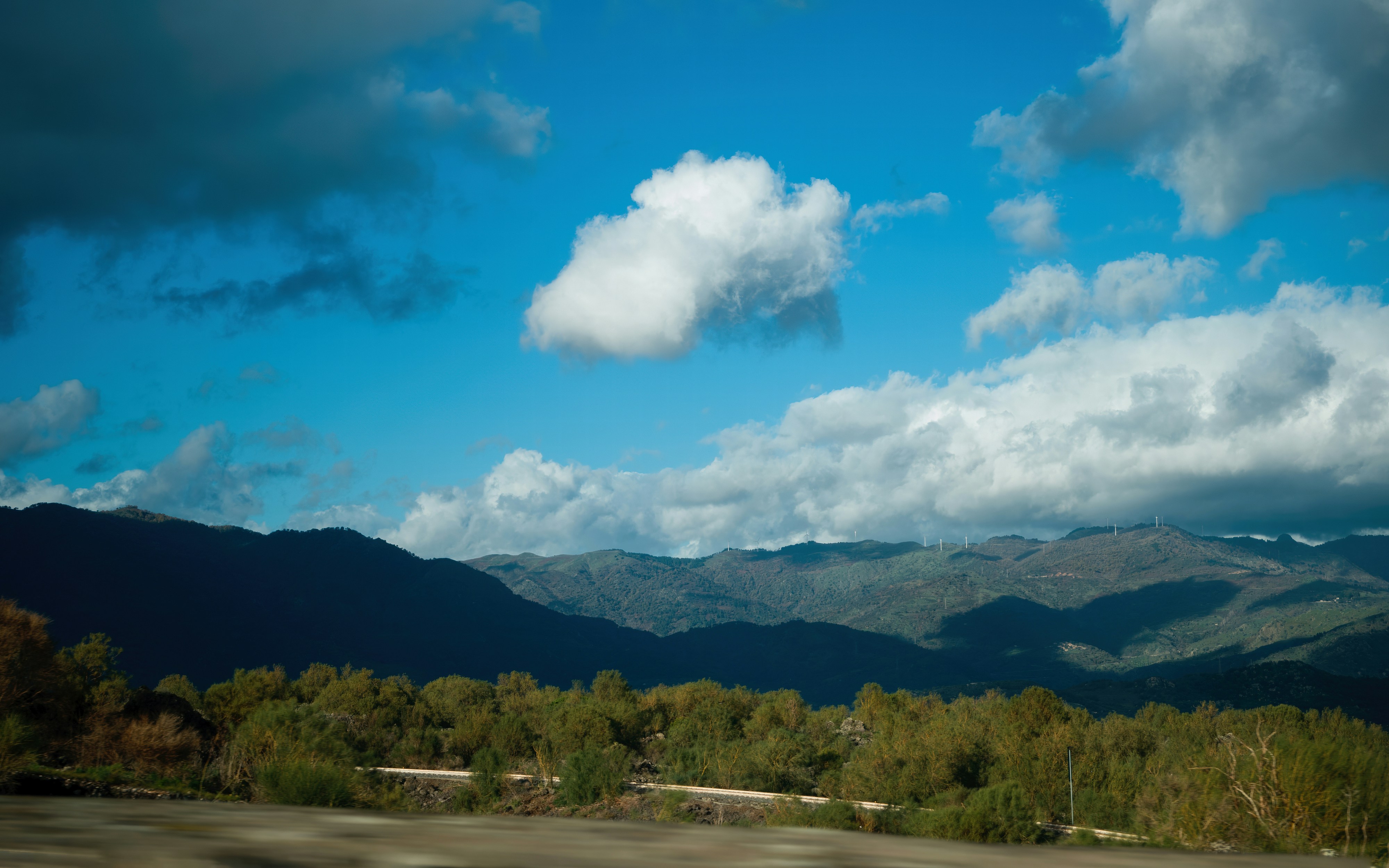 A view of a mountain range with clouds in the sky