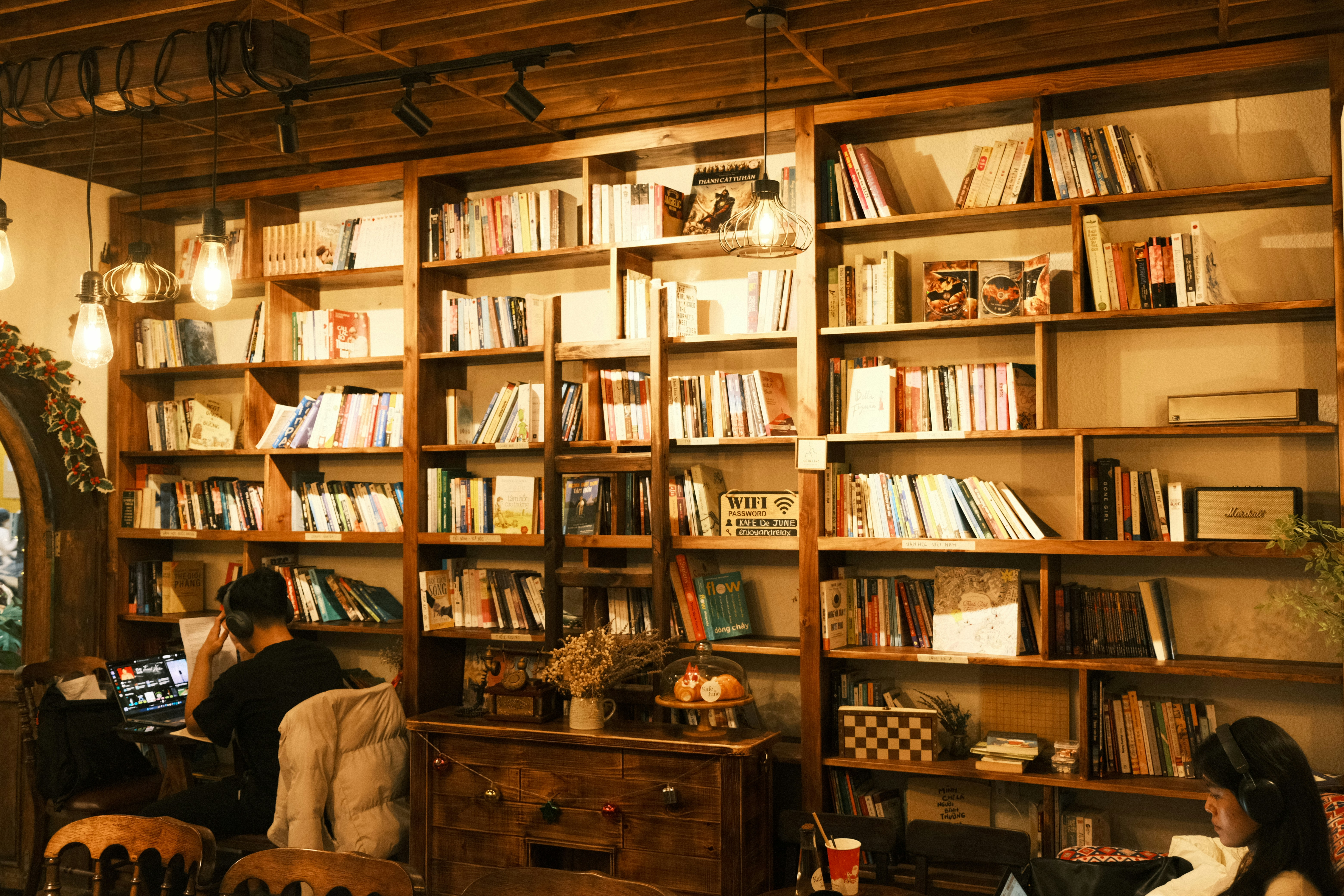 A woman sitting at a table in front of a bookshelf
