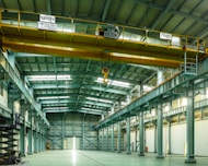 A large warehouse with a yellow crane hanging from the ceiling