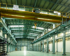 A large warehouse with a yellow crane hanging from the ceiling