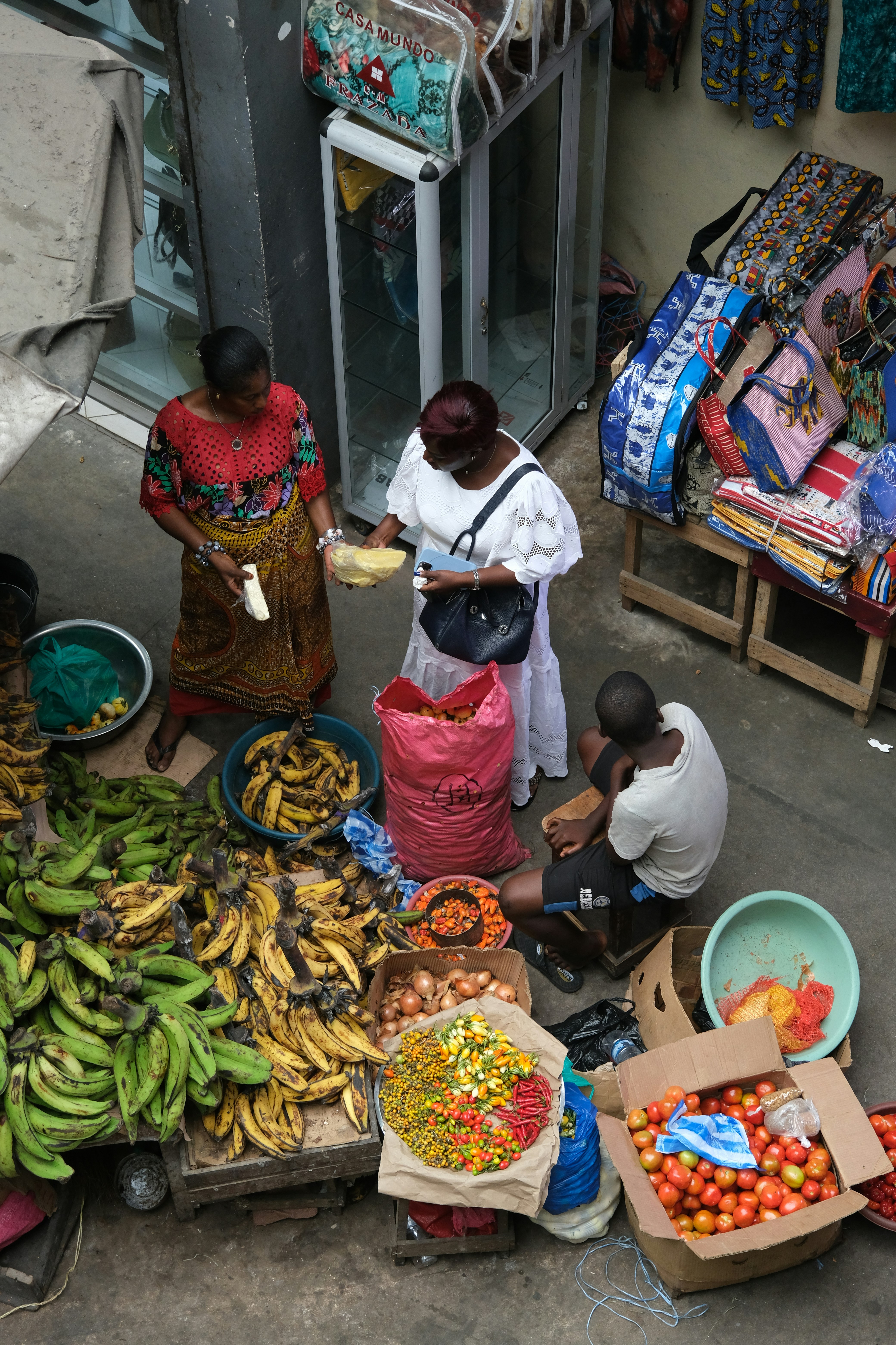 A group of people standing around a table filled with fruits and vegetables
