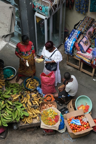 A group of people standing around a table filled with fruits and vegetables