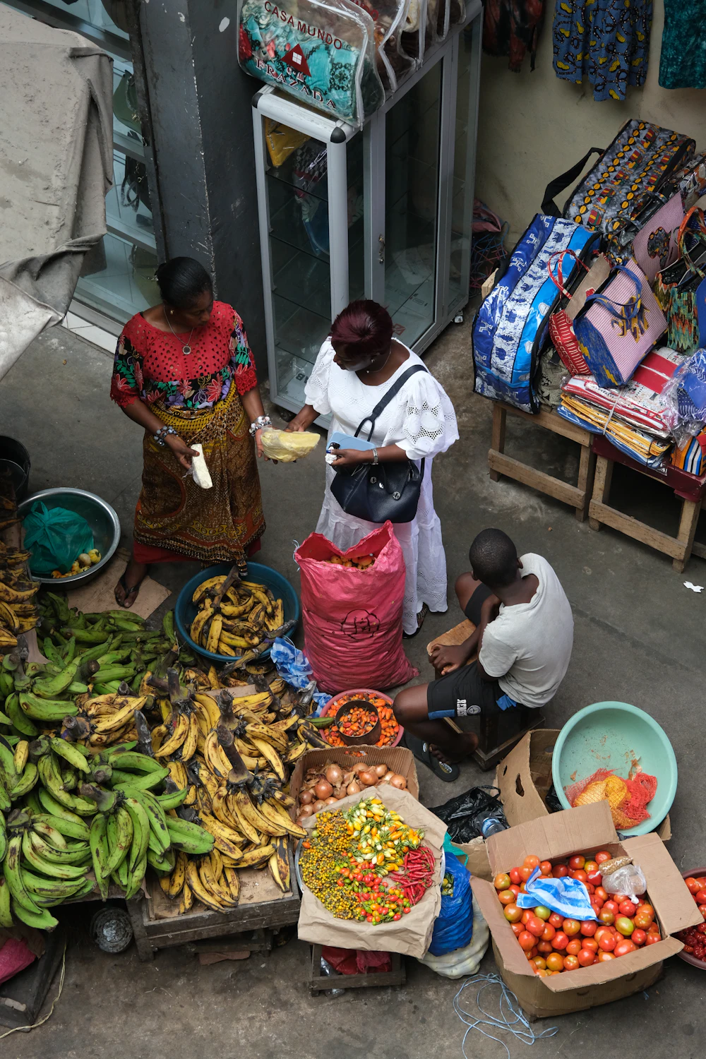 Étal de fruits et légumes entouré de clients