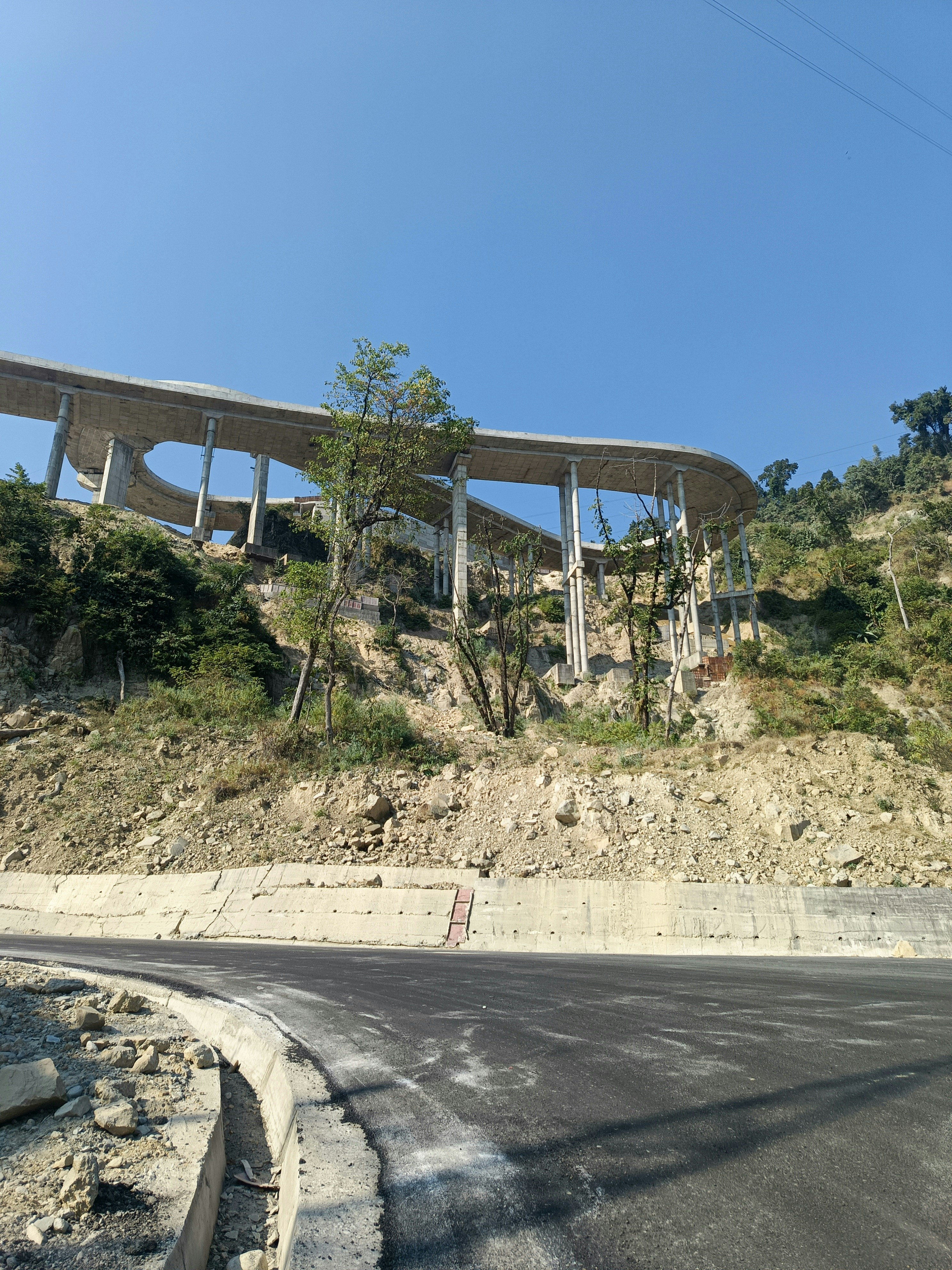 Highway embankment slope with green vegetation, bright daytime, infrastructure construction, open landscape