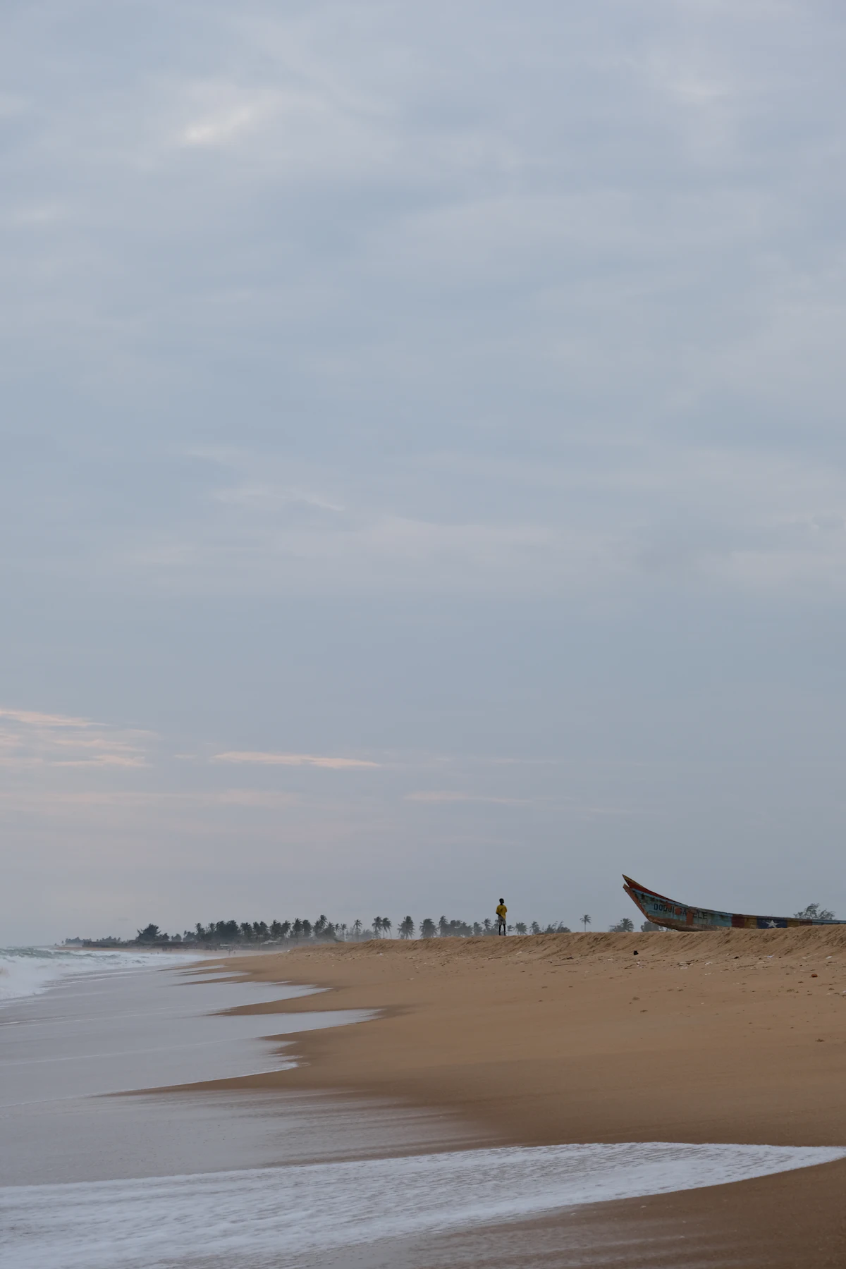 Une pirogue posée sur une plage de sable au Bénin