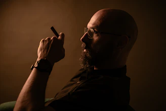 A man holding a cigarette in his right hand