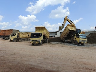 A group of dump trucks parked next to each other