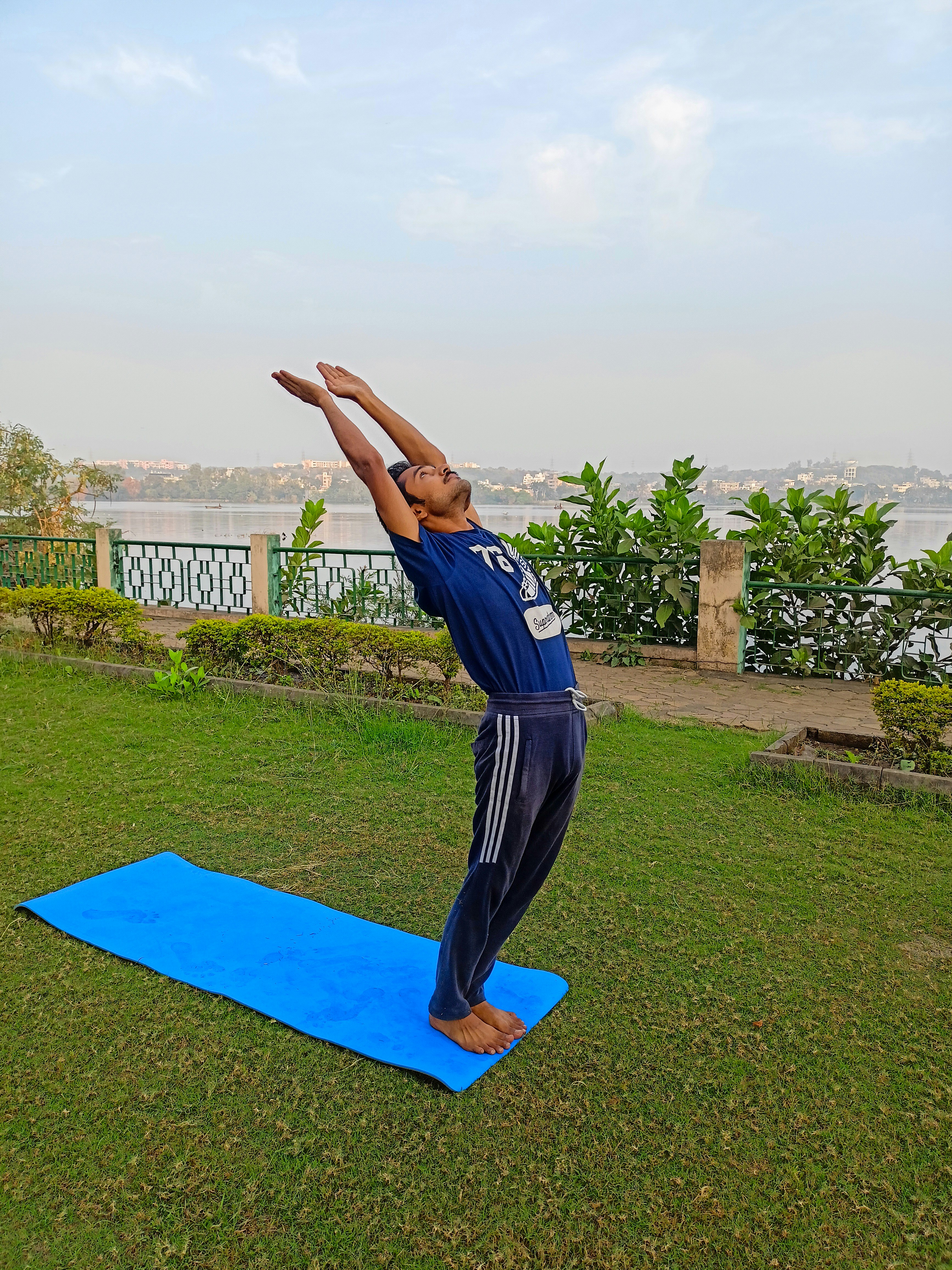 A man doing a yoga pose on a blue mat