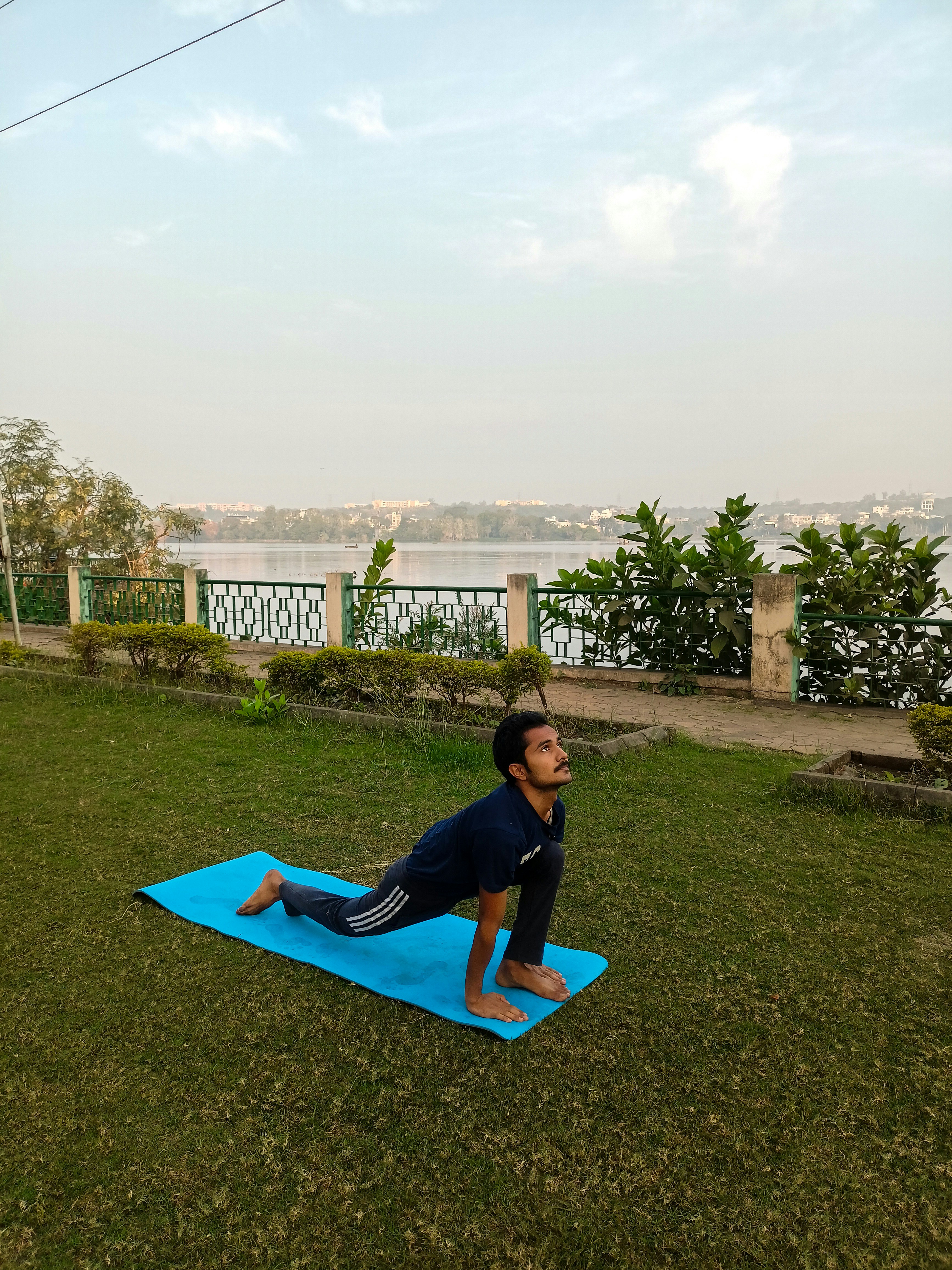 A man doing a yoga pose on a blue mat