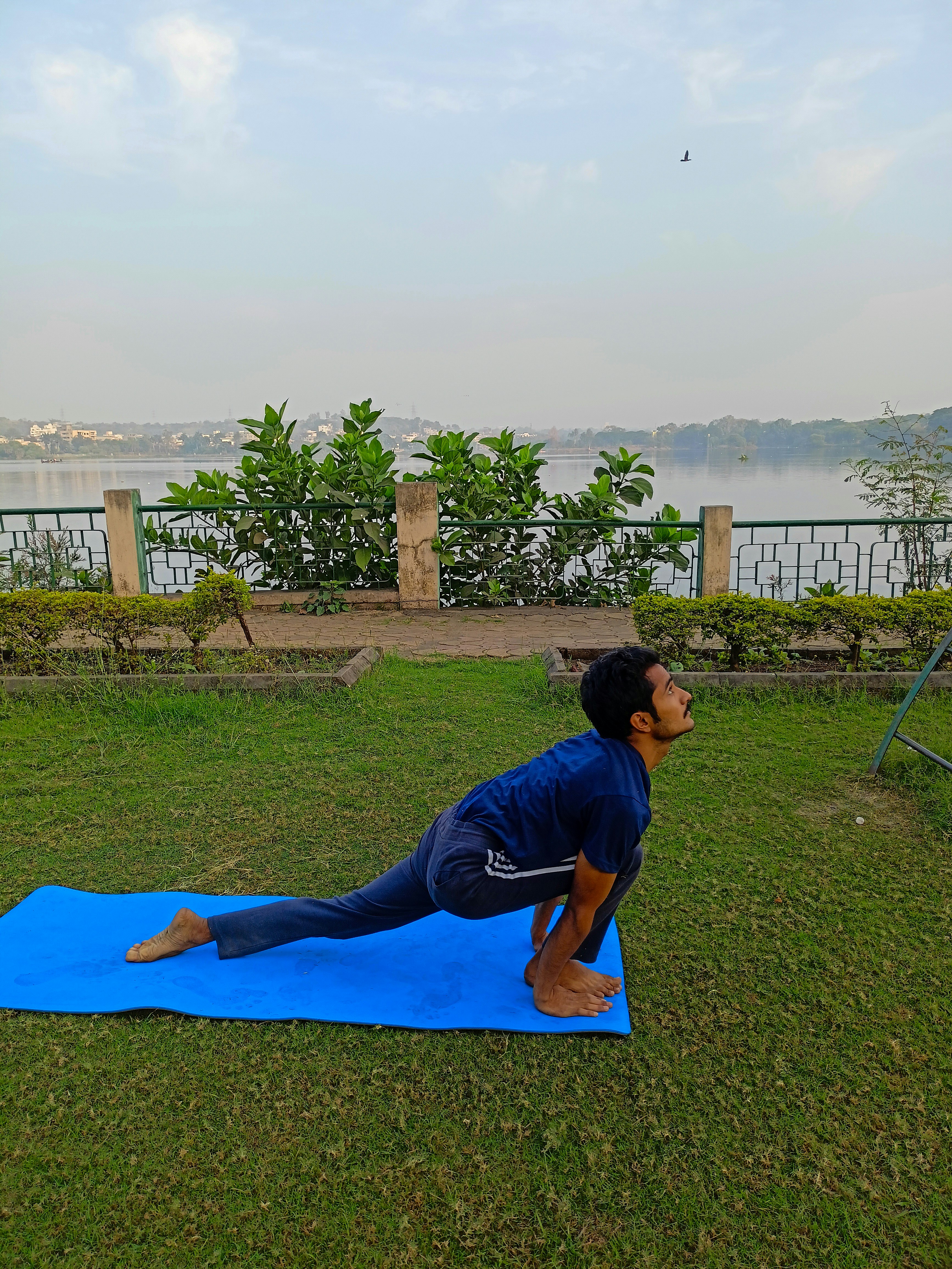 A man doing a yoga pose on a blue mat