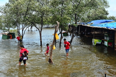 A group of people walking through a flooded street