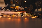 A man working with a grinder on a piece of metal