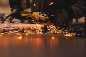 A man working with a grinder on a piece of metal