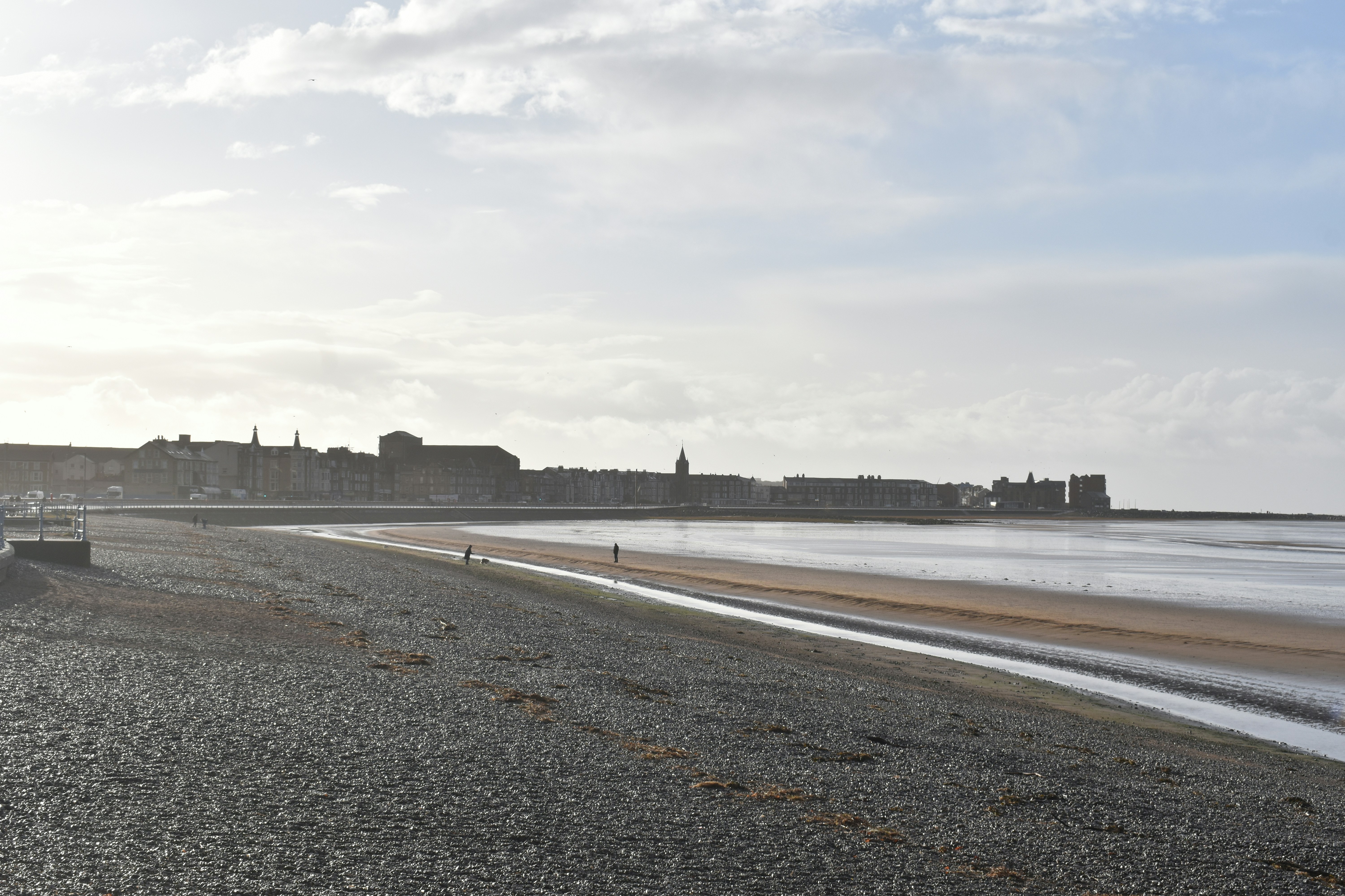 A sandy beach next to a body of water