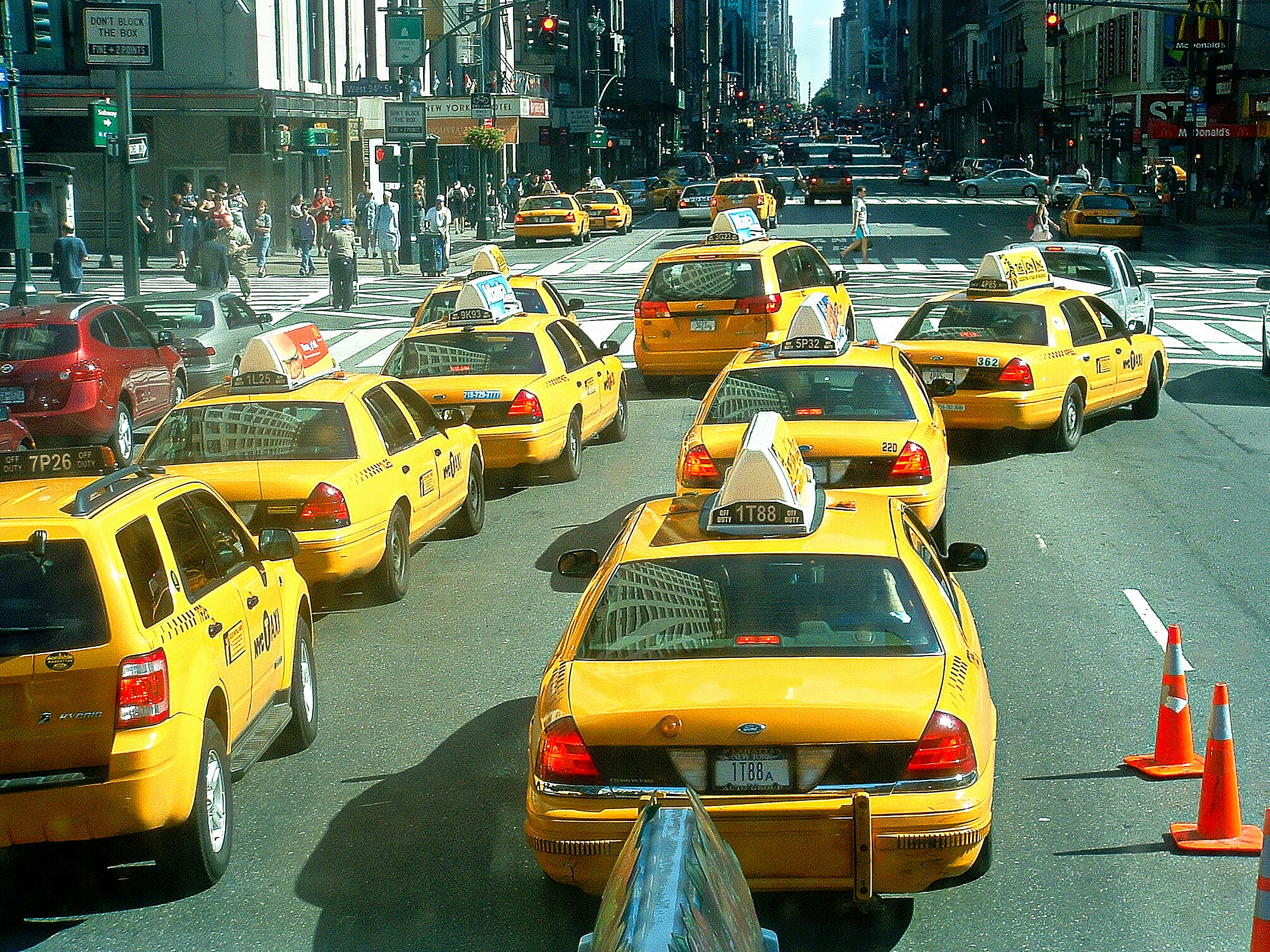 A city street filled with lots of yellow taxis