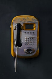 An old style telephone with a cord attached to it
