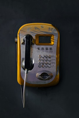 An old style telephone with a cord attached to it