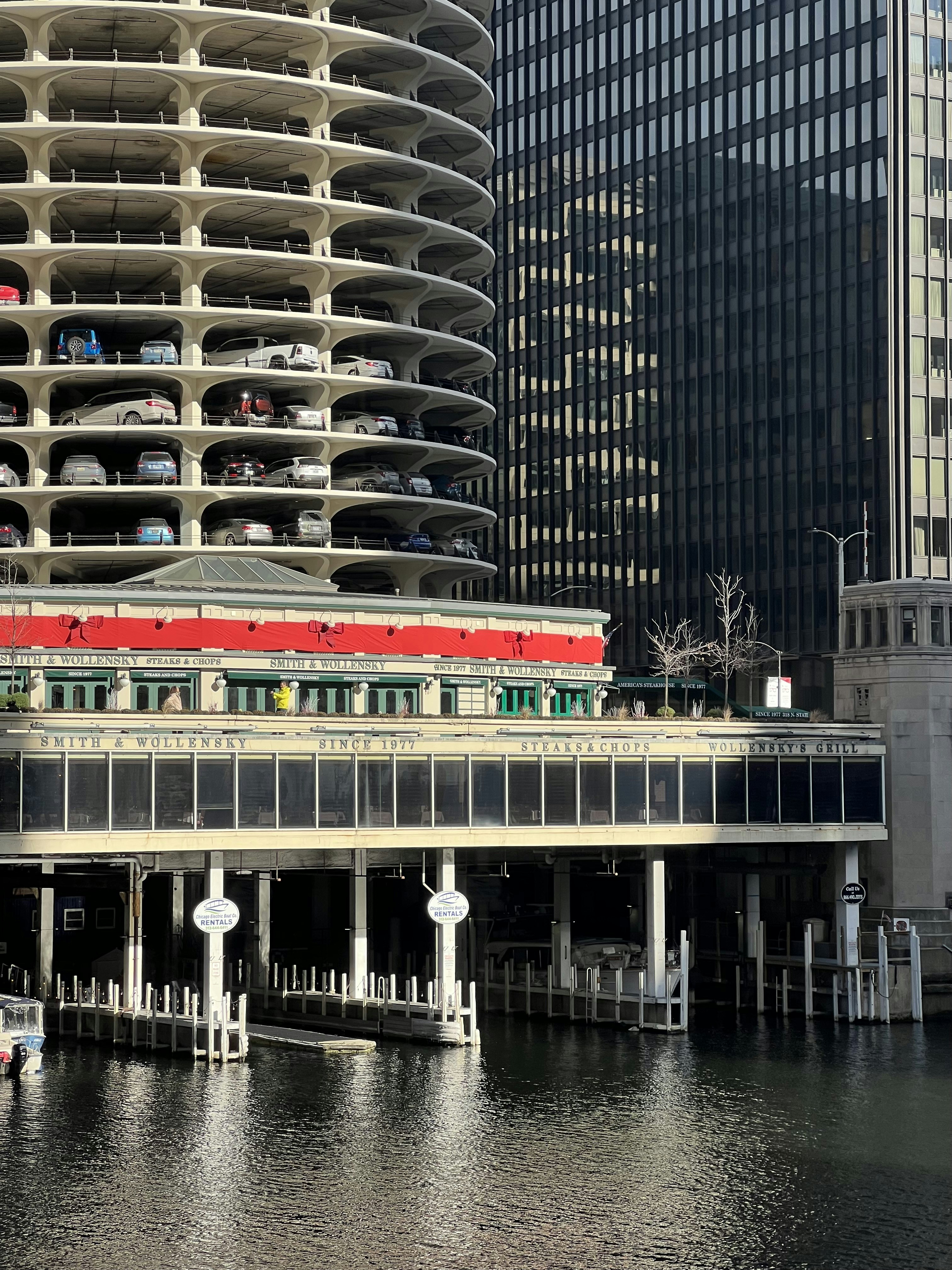 A red and white train is on a bridge over water