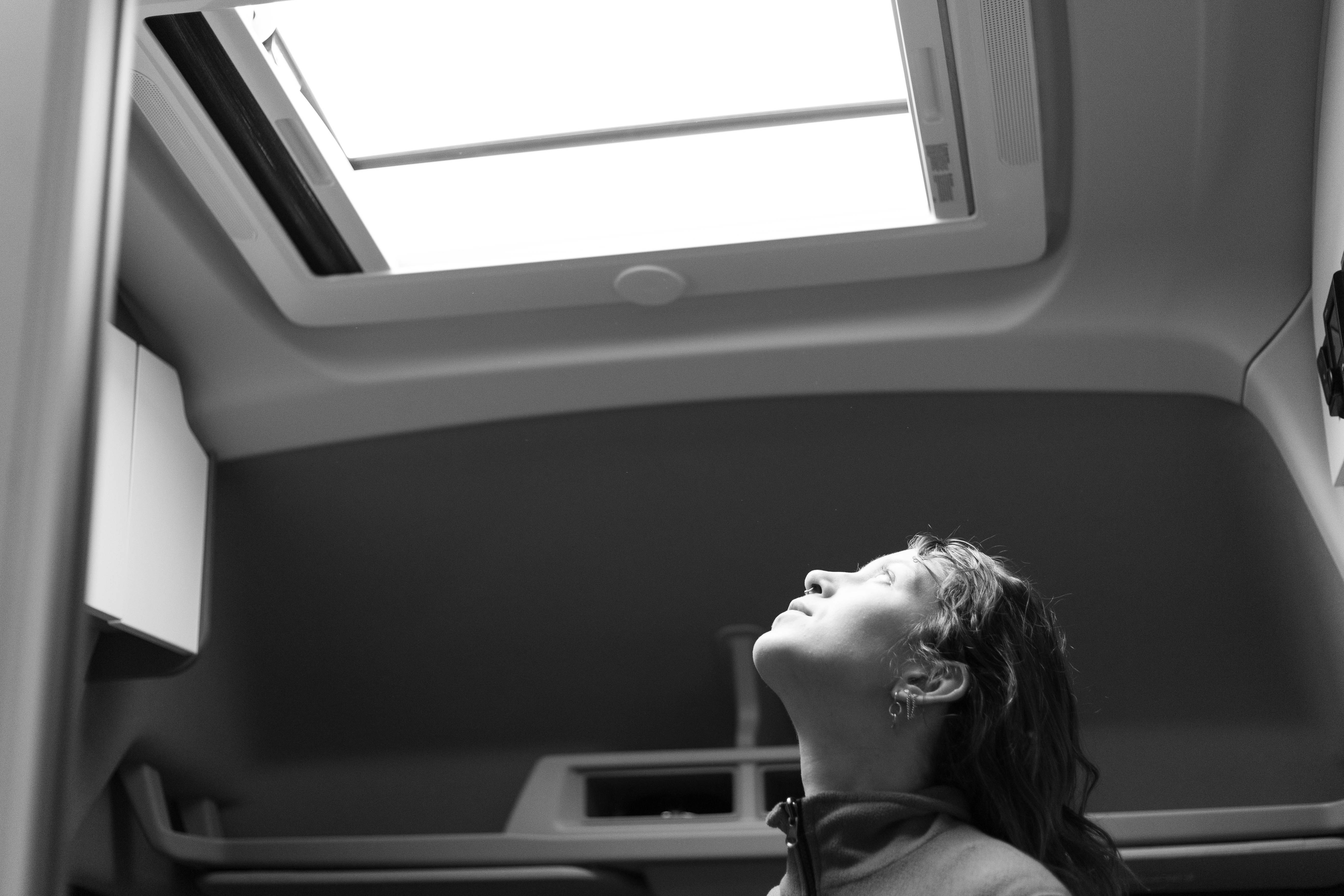 A little girl looking up at a skylight