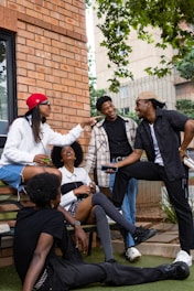 A group of people sitting on a bench outside of a building
