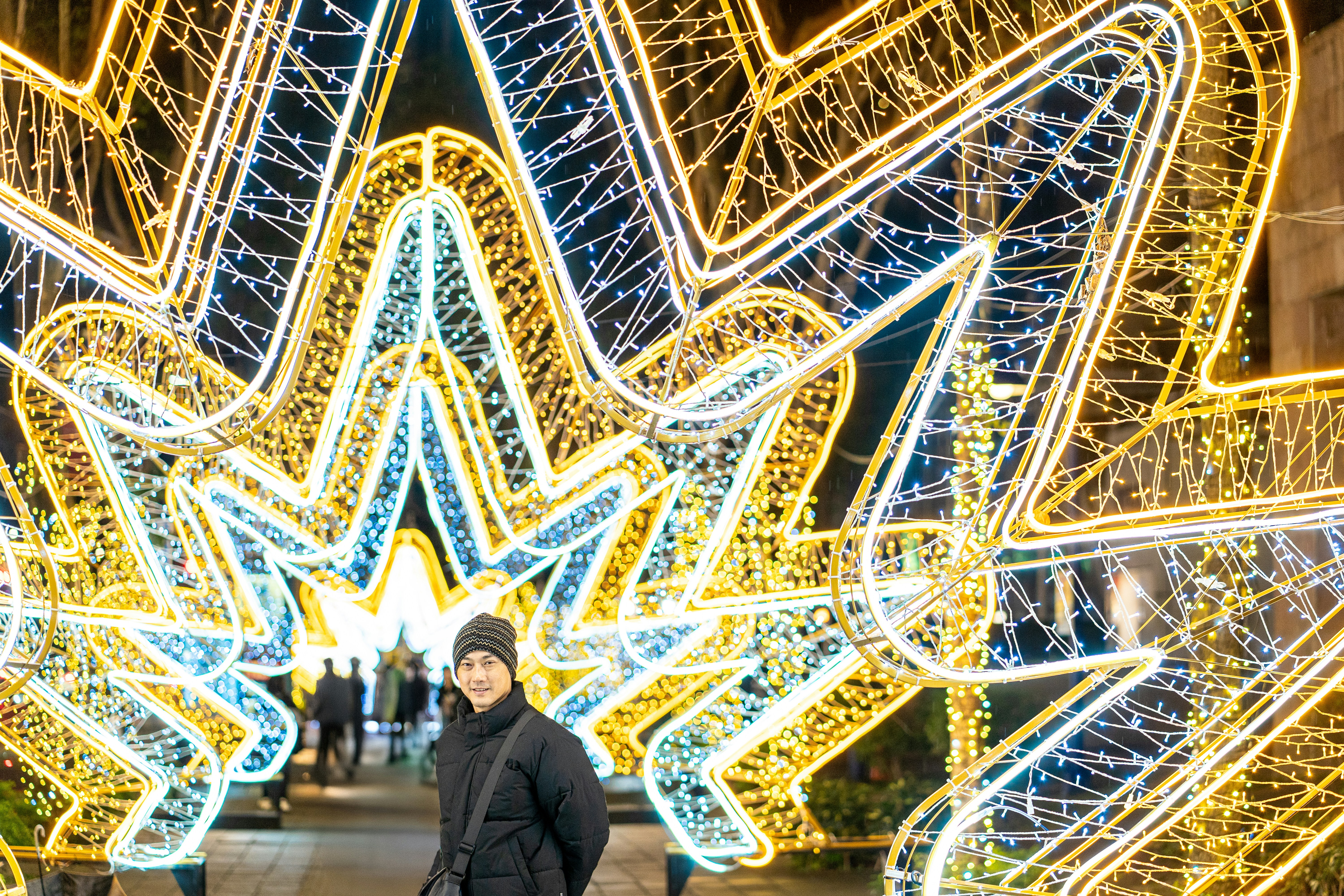 大きなライトアップの前に立つ男性