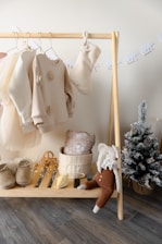 A wooden shelf with a bunch of baby clothes on it