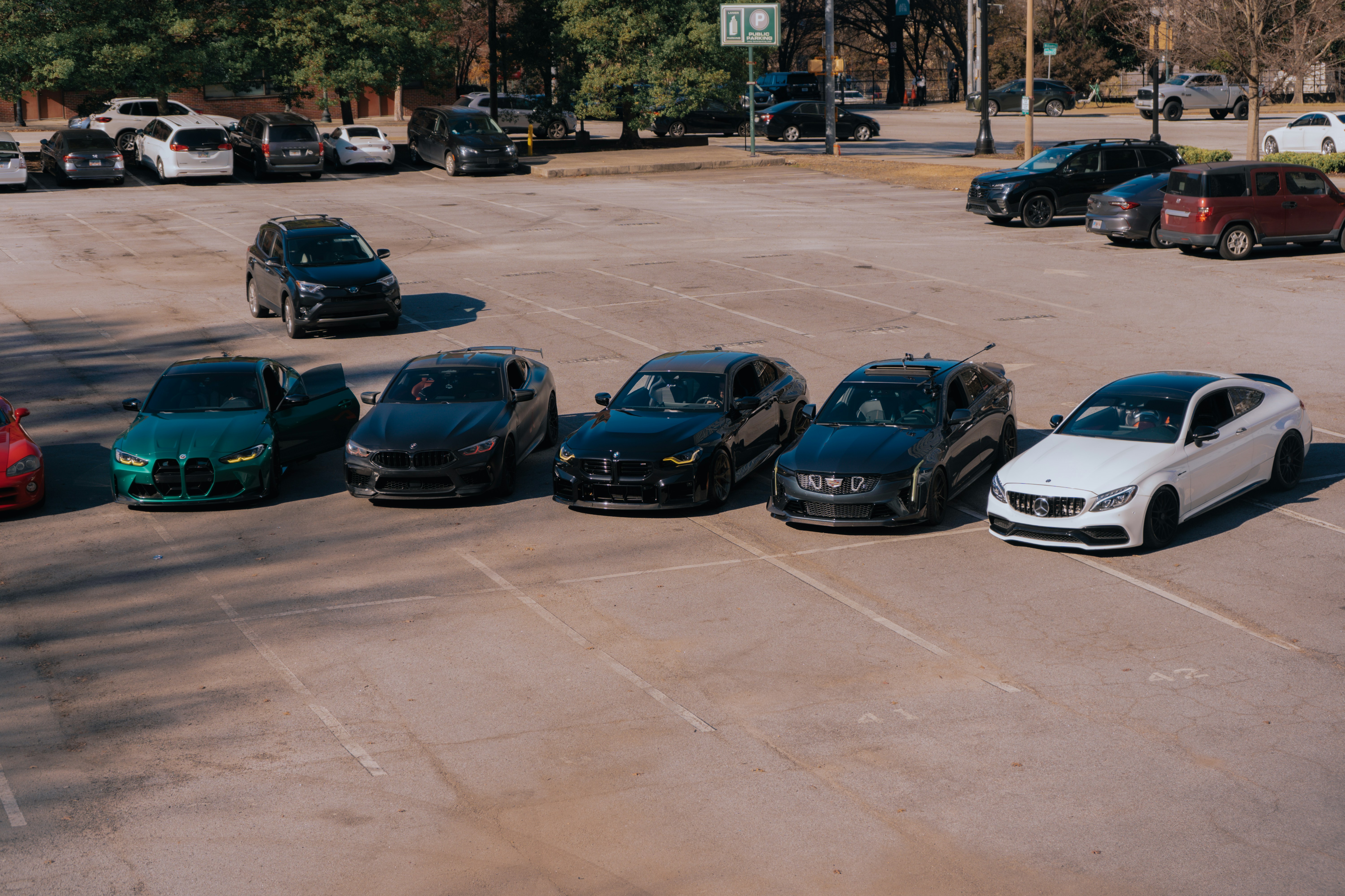Row of used electric vehicles parked on a dealership lot under daylight