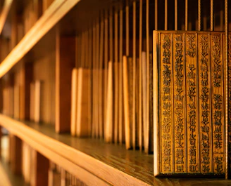 A row of books sitting on top of a wooden shelf