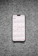 A white and black phone sitting on top of a gray surface