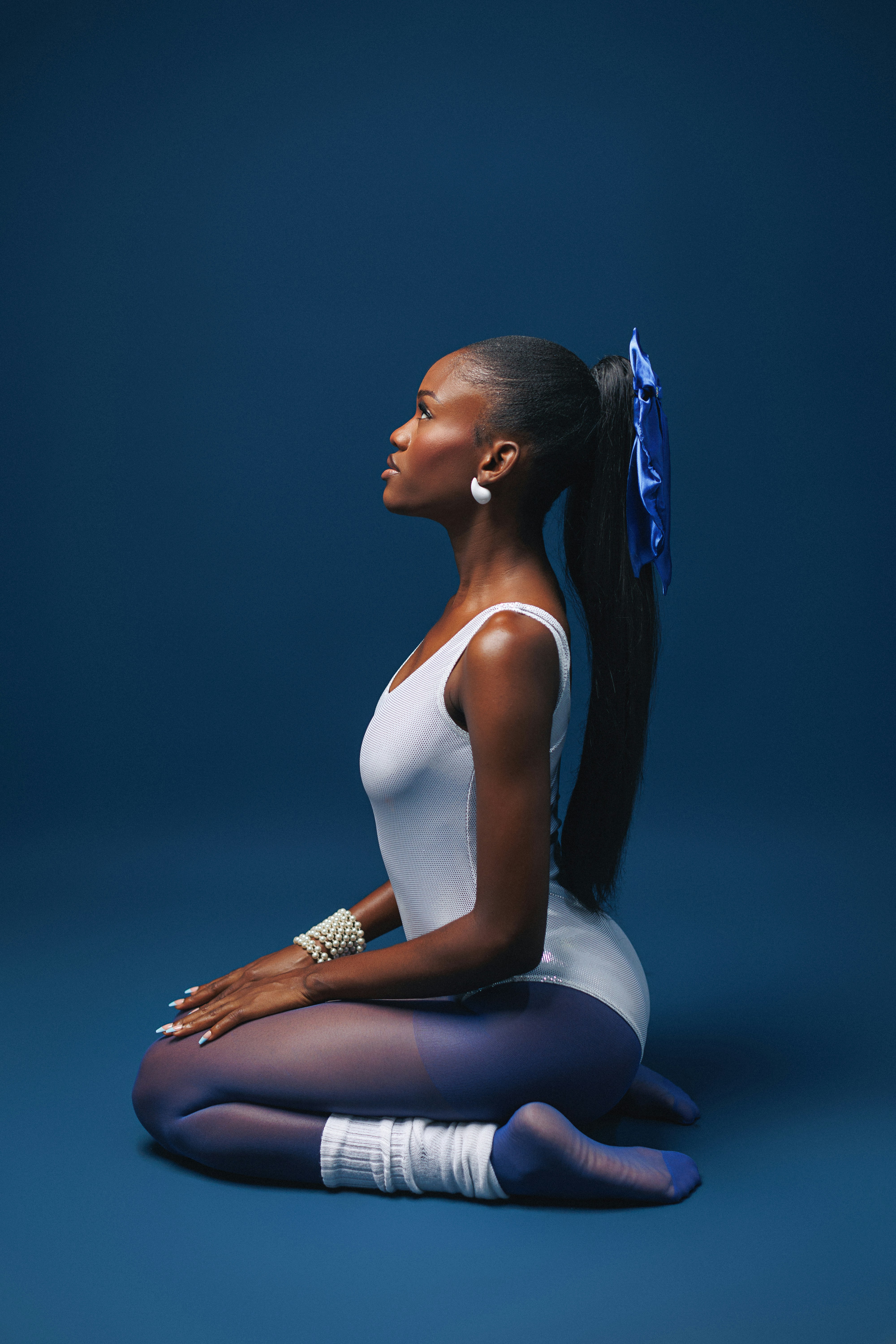 A woman sitting on the ground with a ponytail in her hair