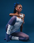 A woman is sitting on the ground with her legs crossed