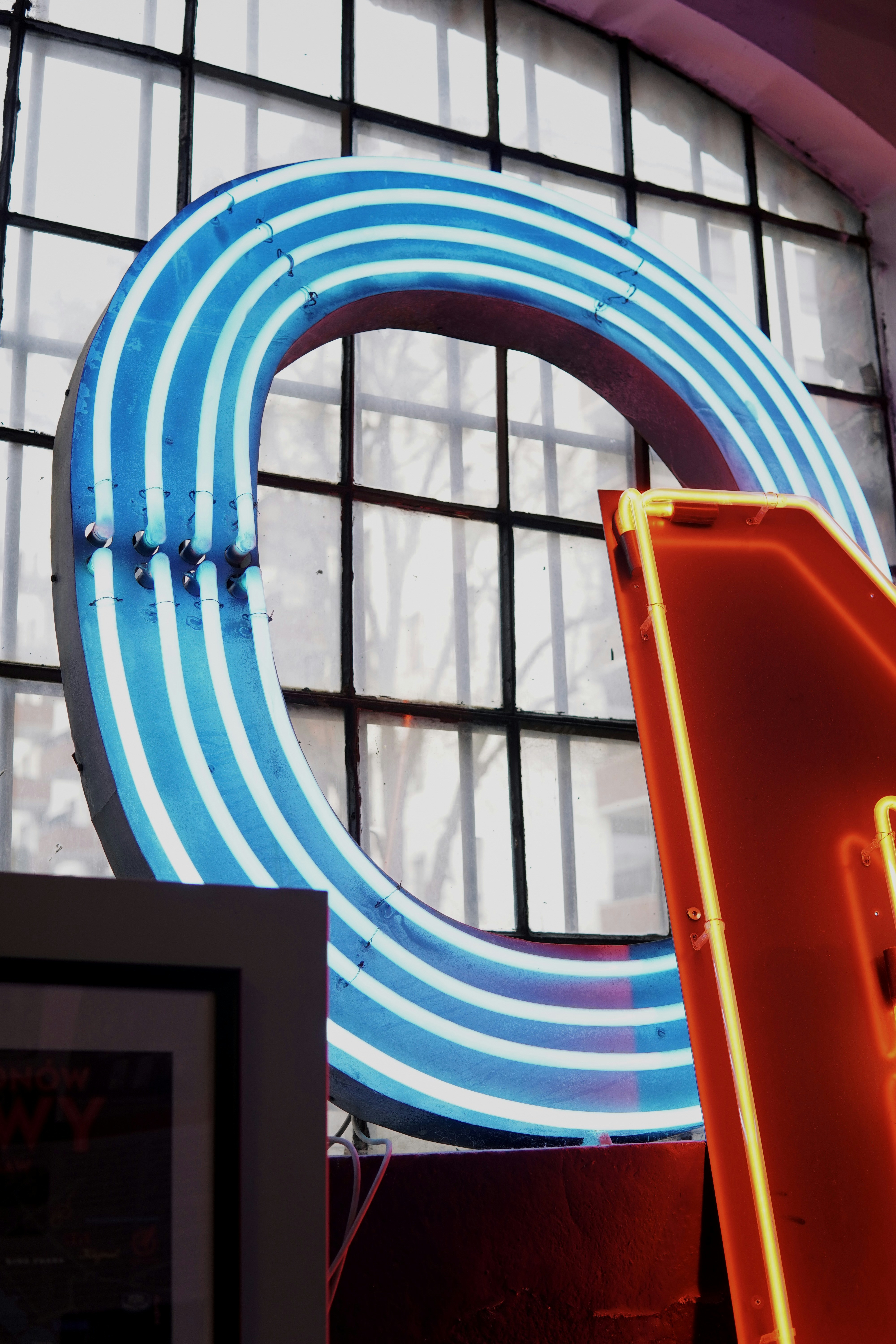 A neon sign in front of a large window