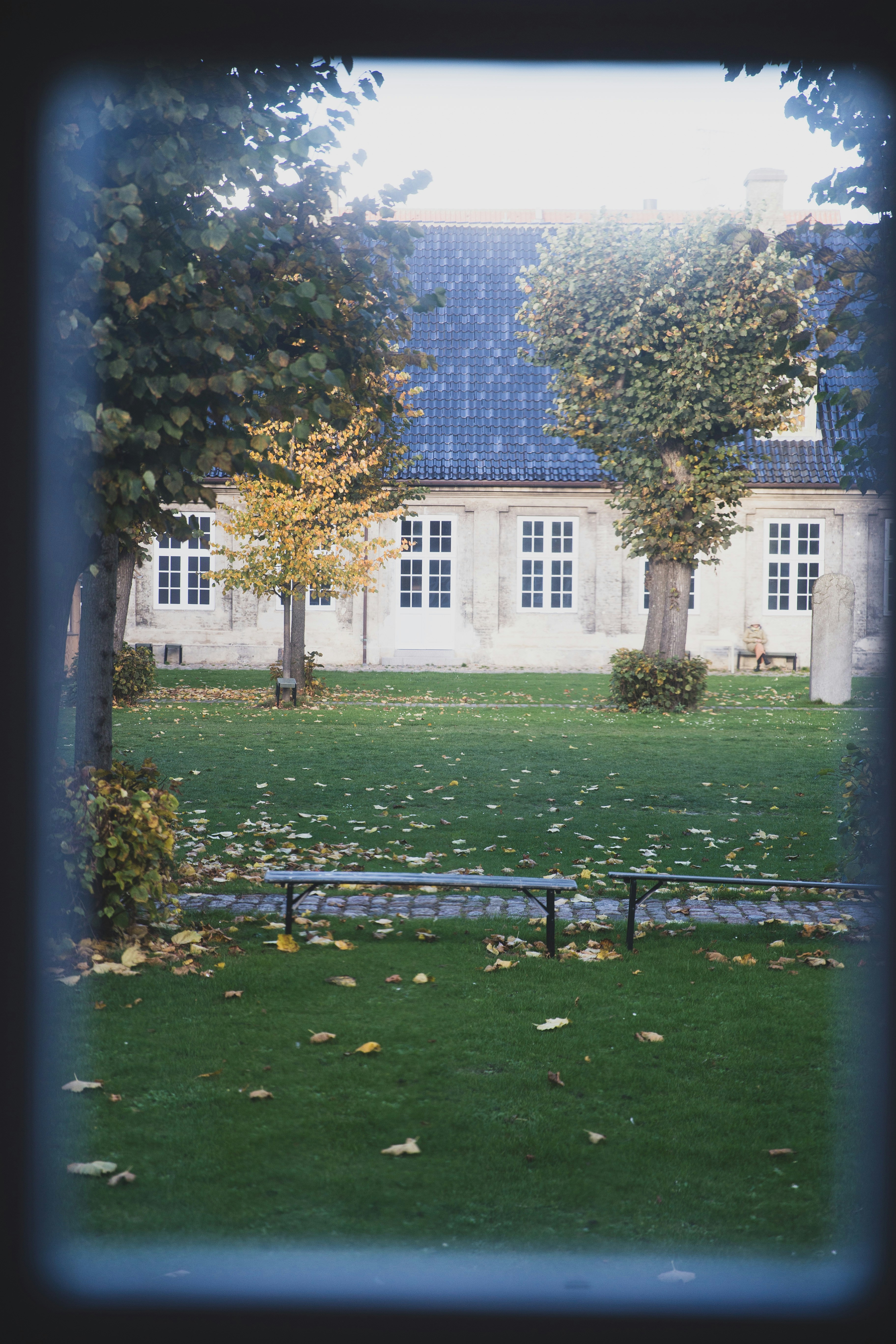 A large building with a blue roof and trees in front of it