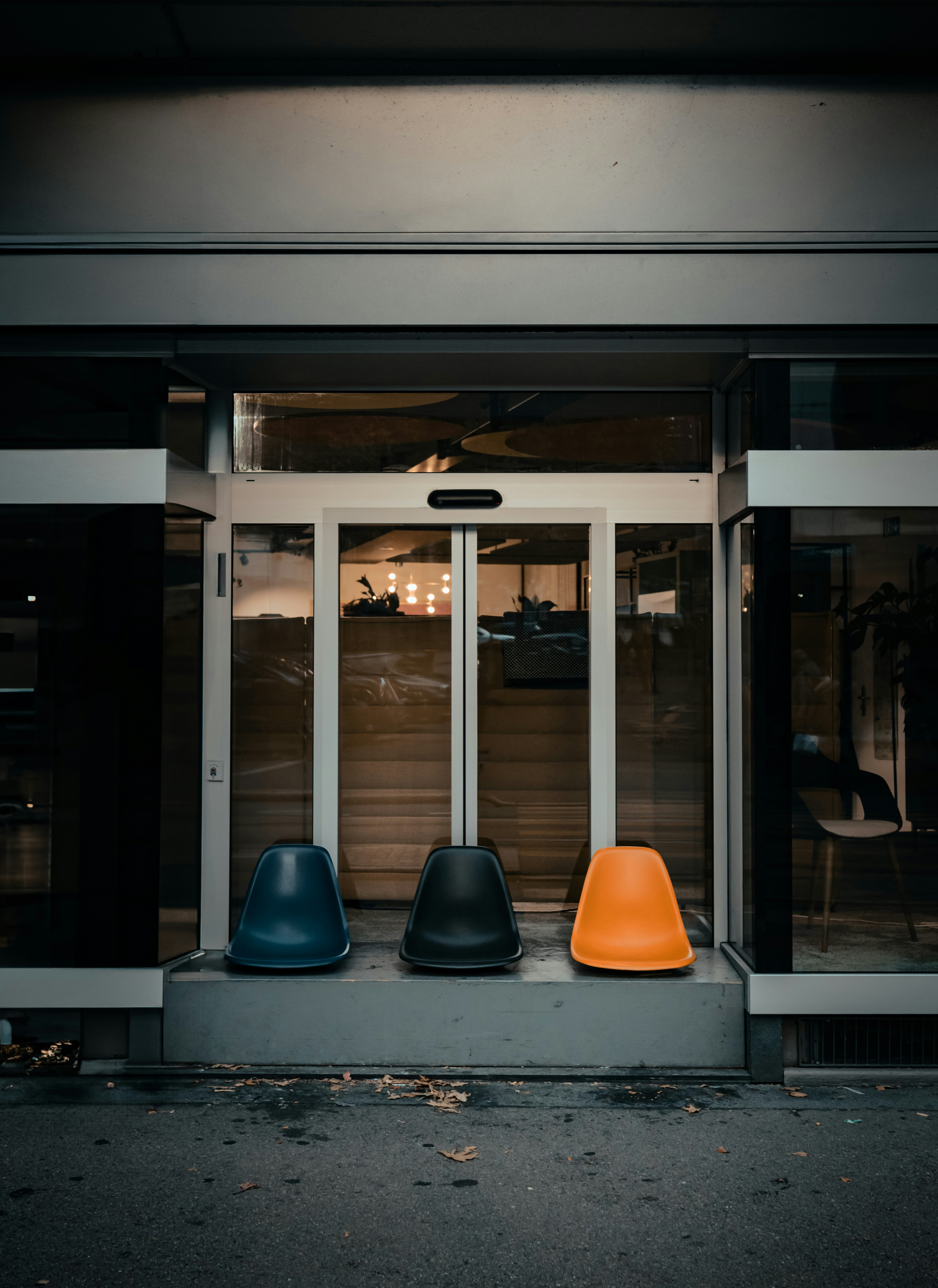 A couple of blue and orange chairs sitting in front of a building