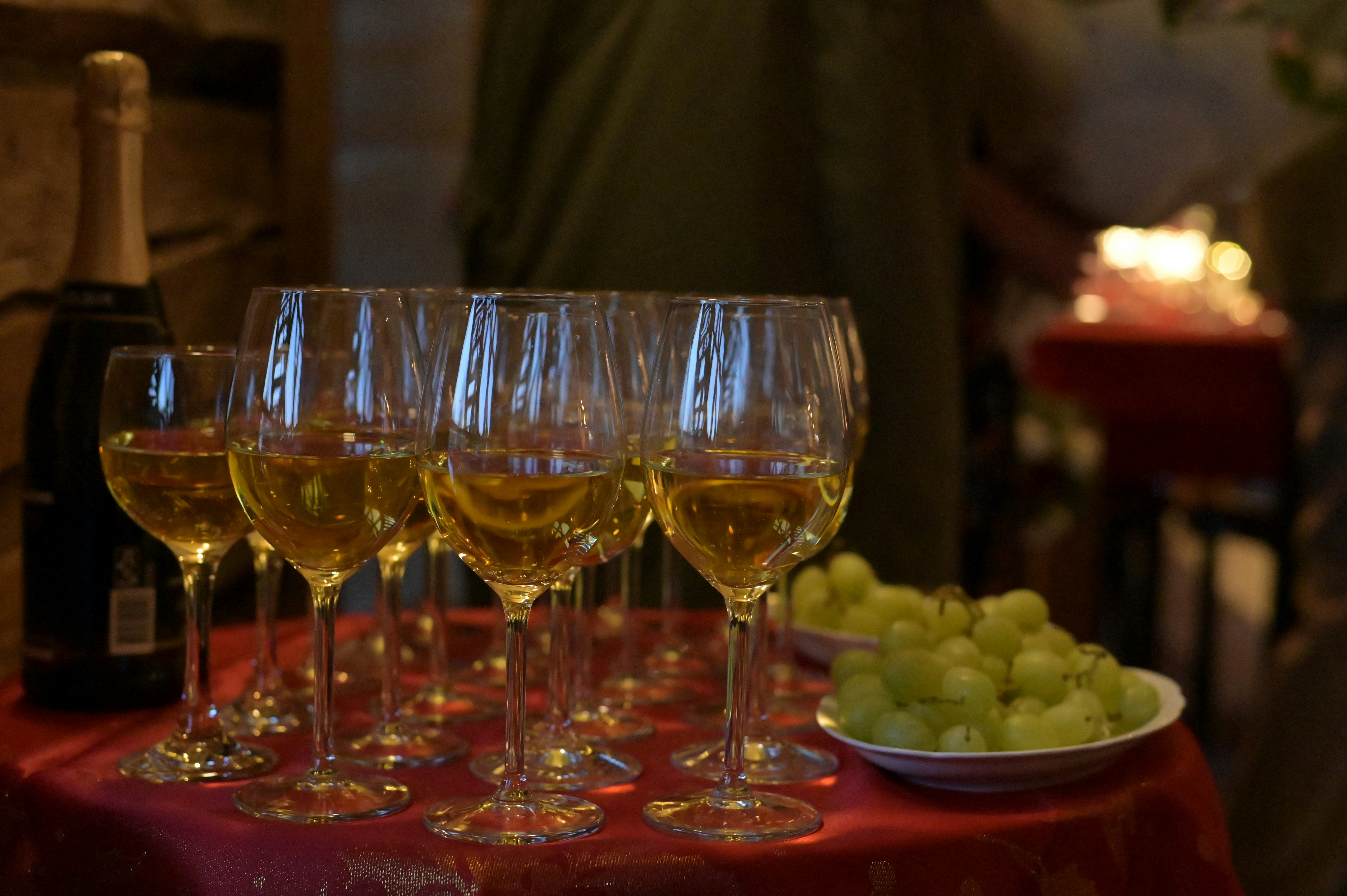 A table topped with lots of glasses of wine