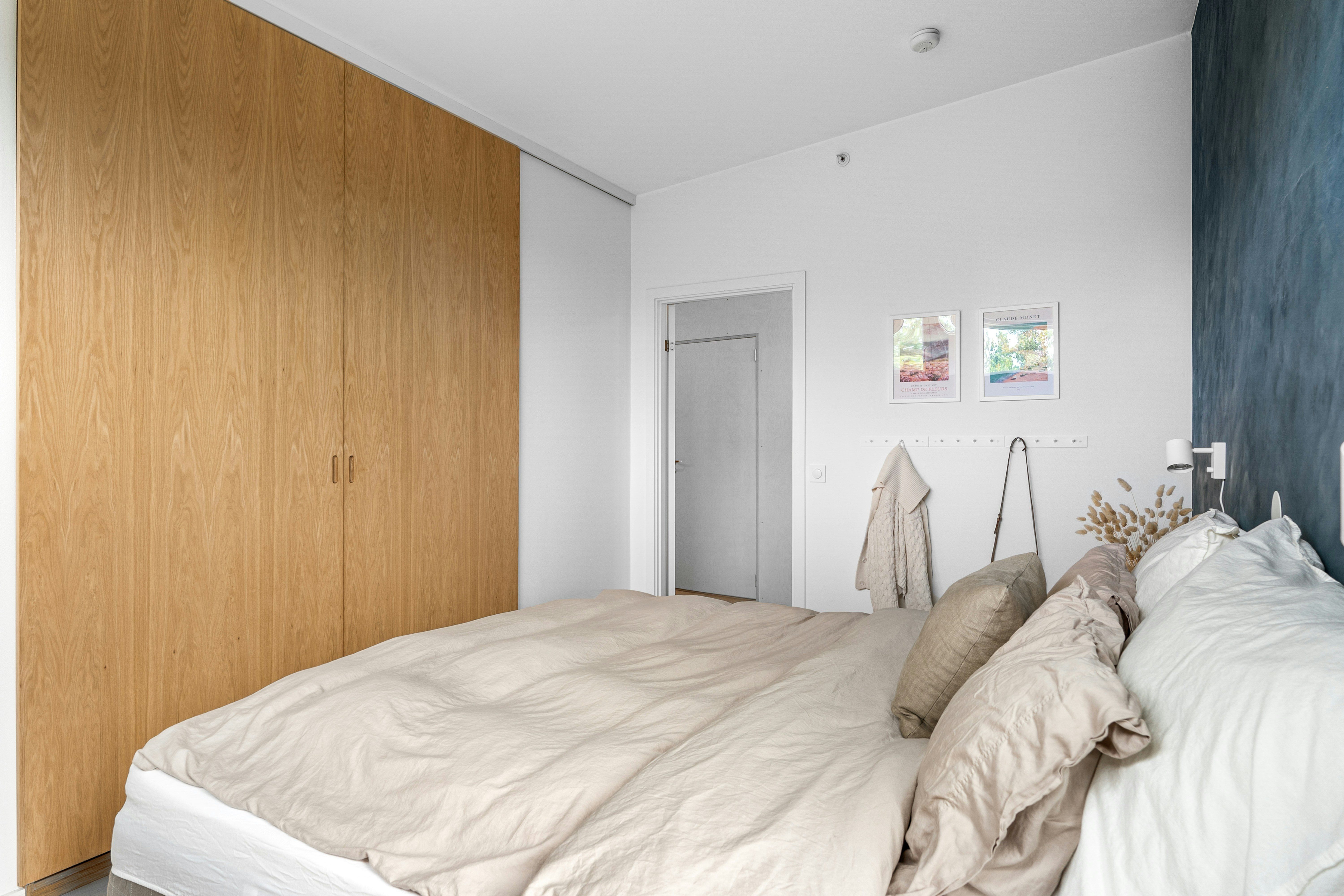 A bedroom with a large bed and a wooden headboard
