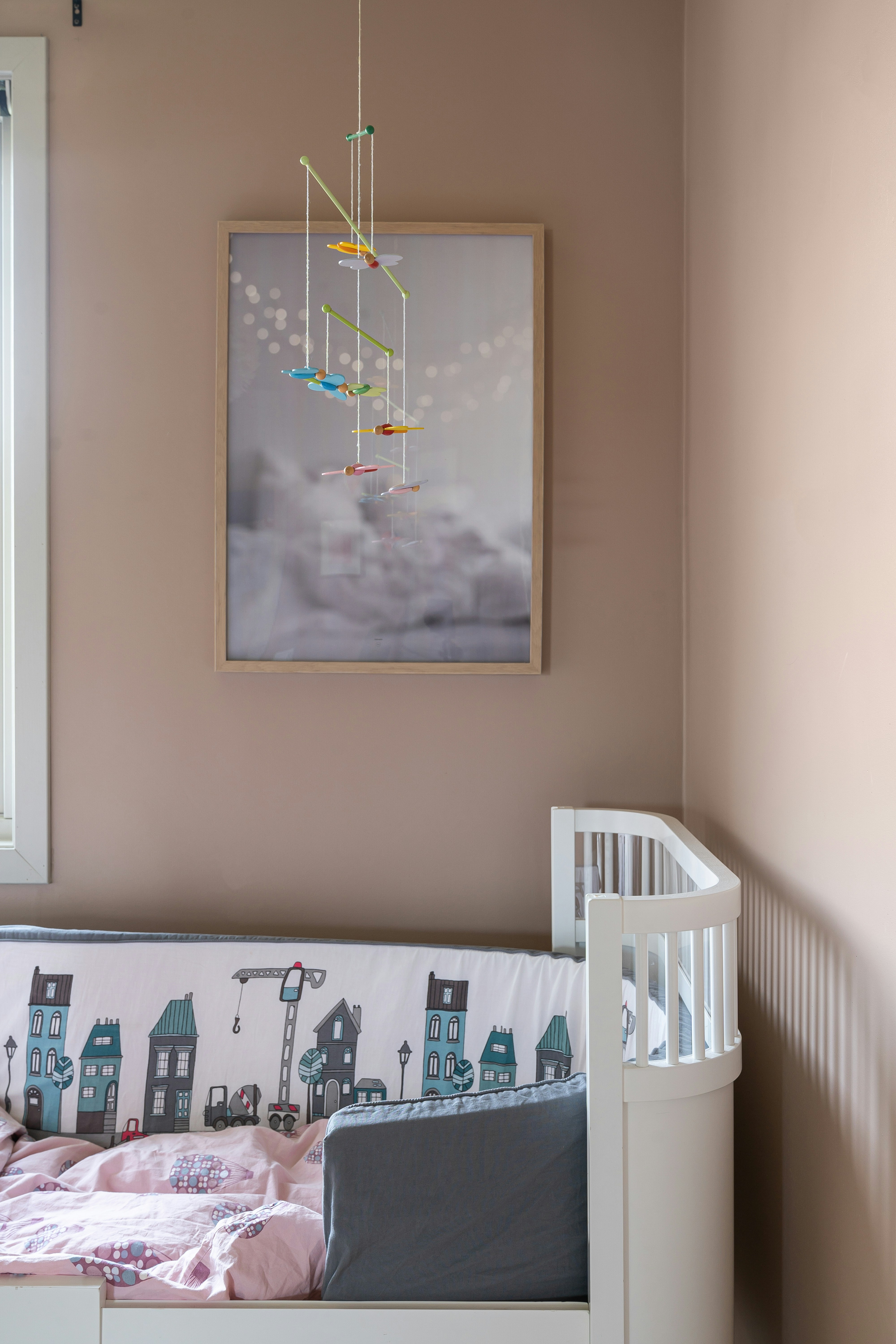 A baby's crib with a picture hanging above it
