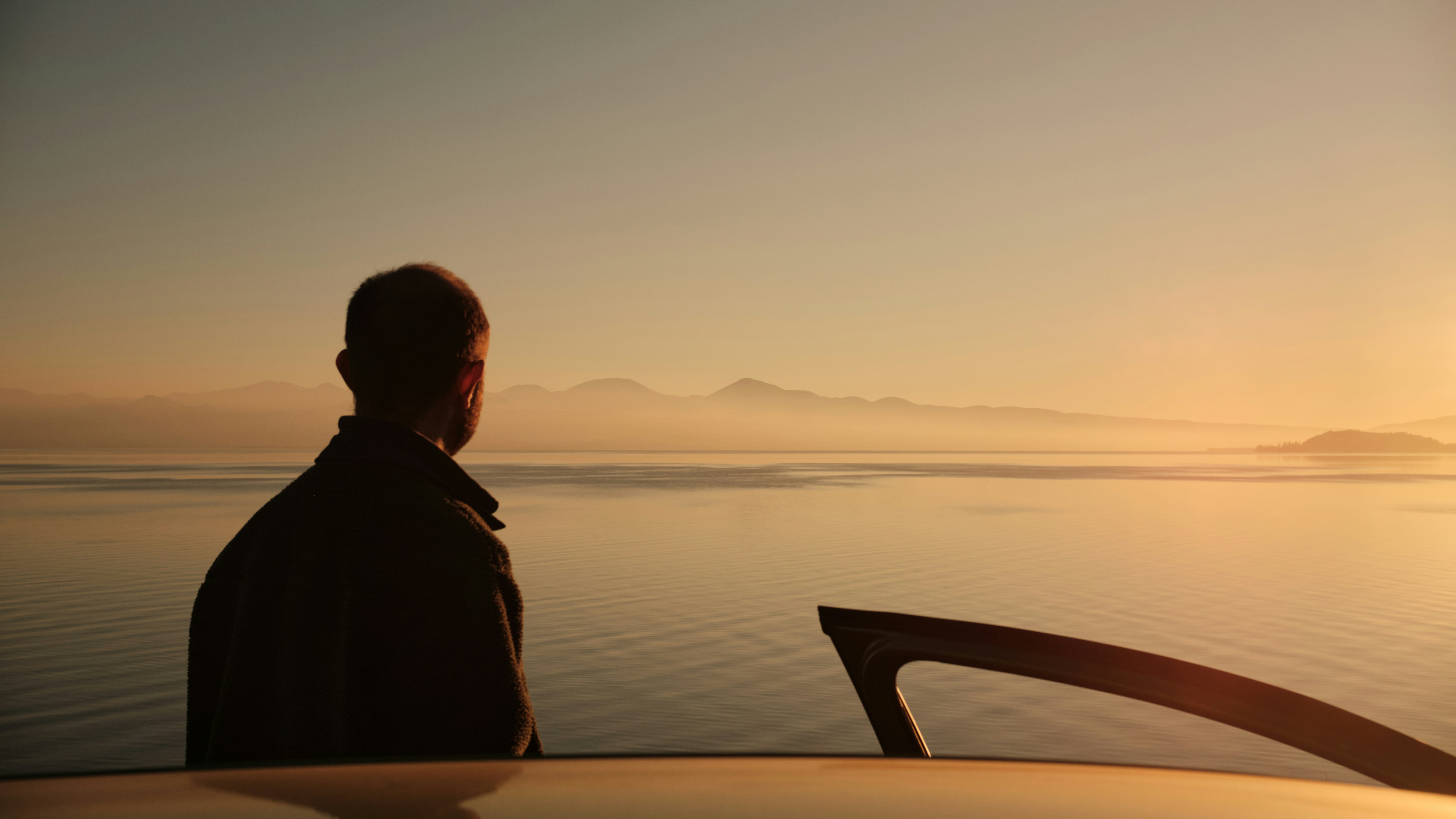 水面のサーフボードの隣に立っている男性