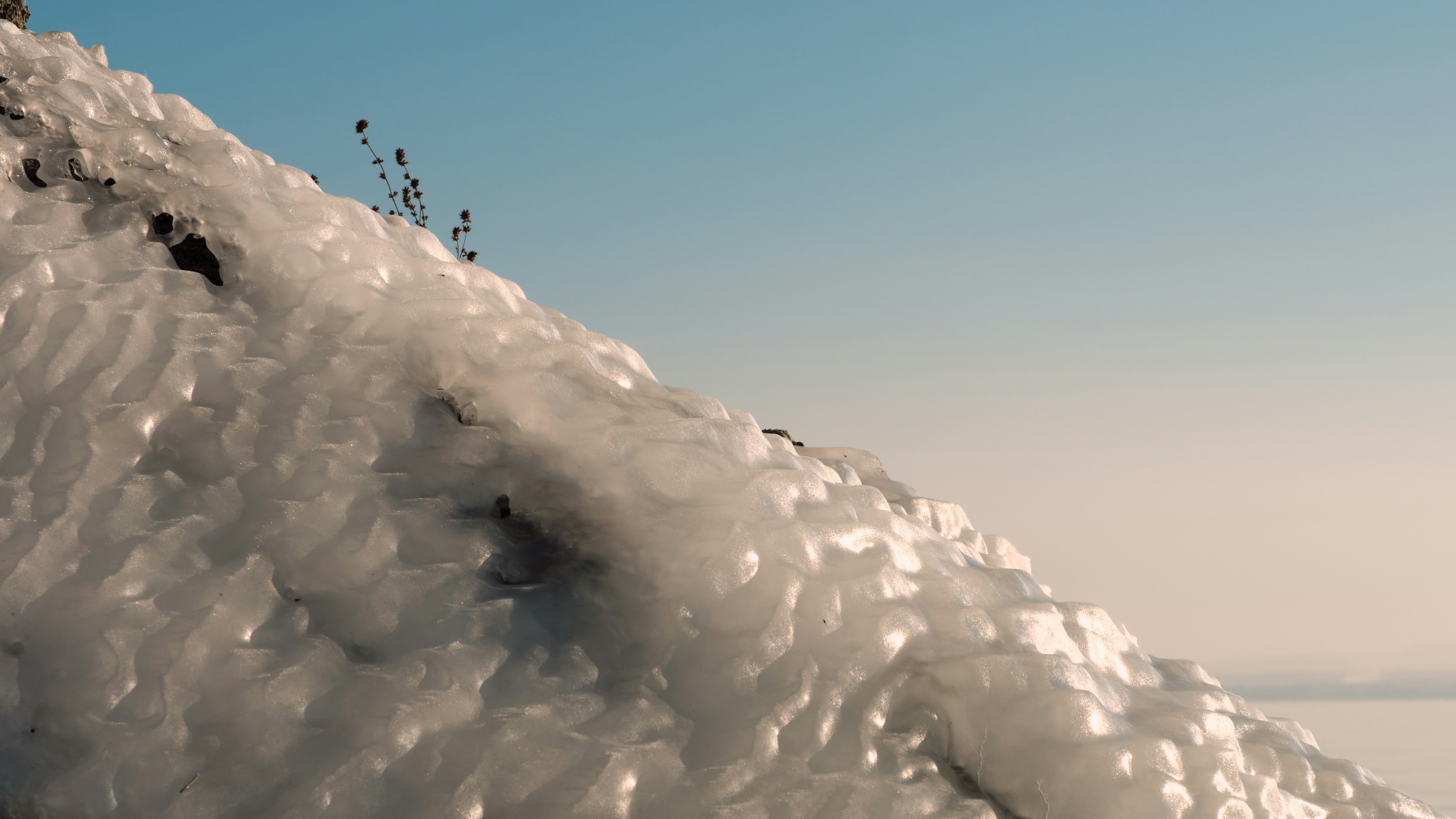 雪に覆われた斜面をスノーボードで下る男性