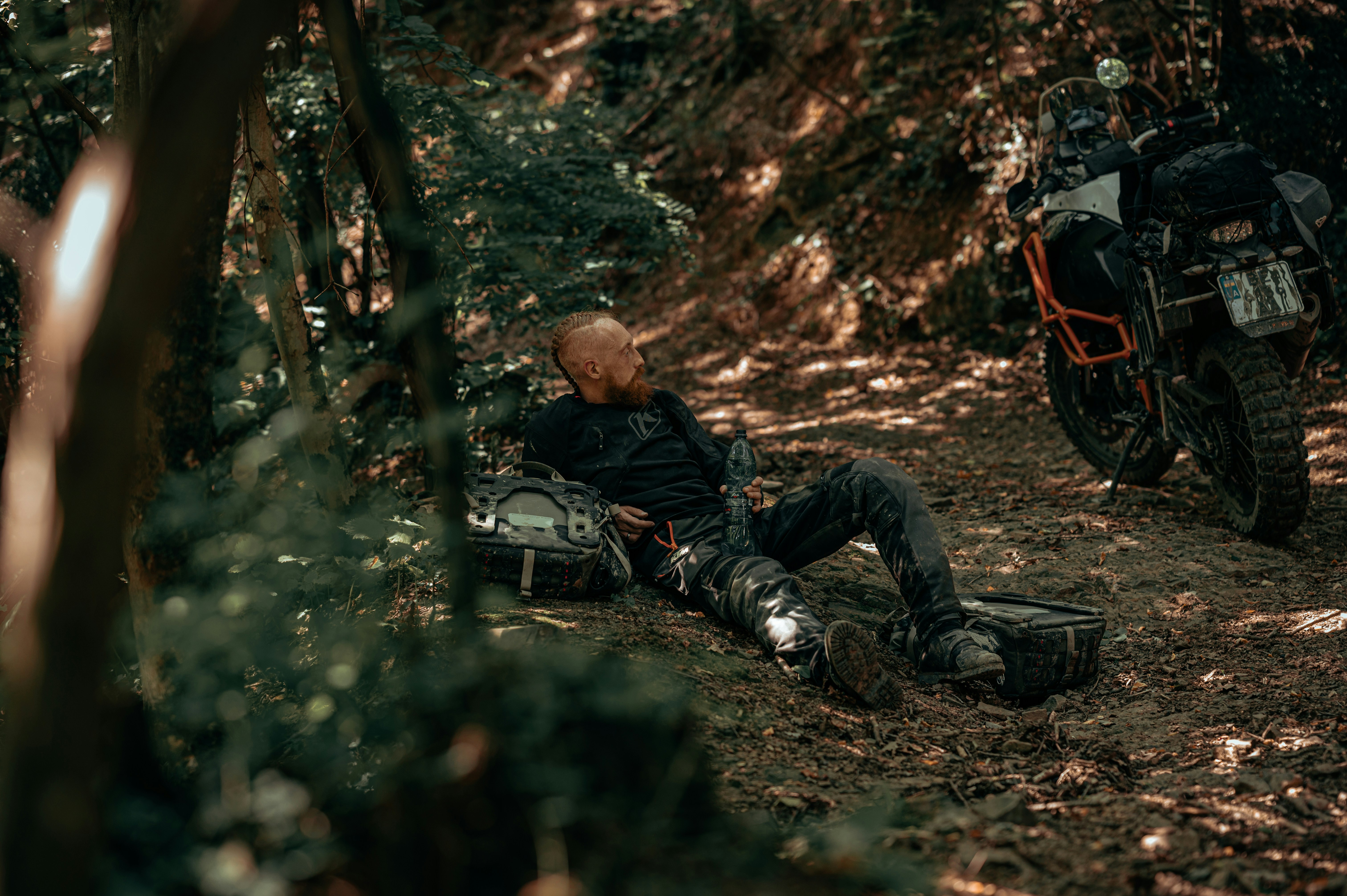 A man laying on the ground next to a motorcycle