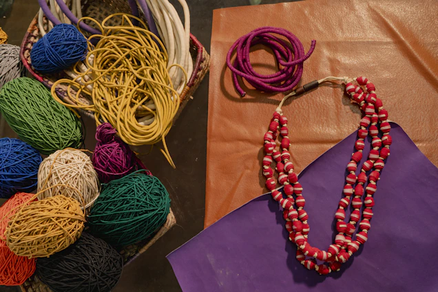 A purple bag sitting next to a bunch of yarn