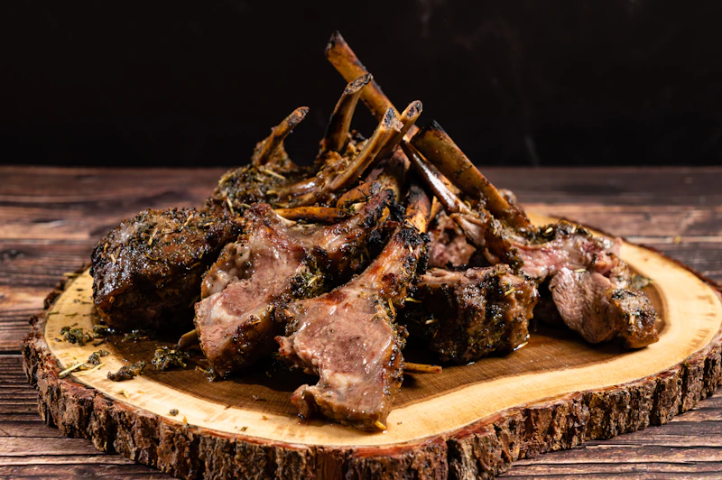 Roasted lamb chops plated on a rustic wooden table