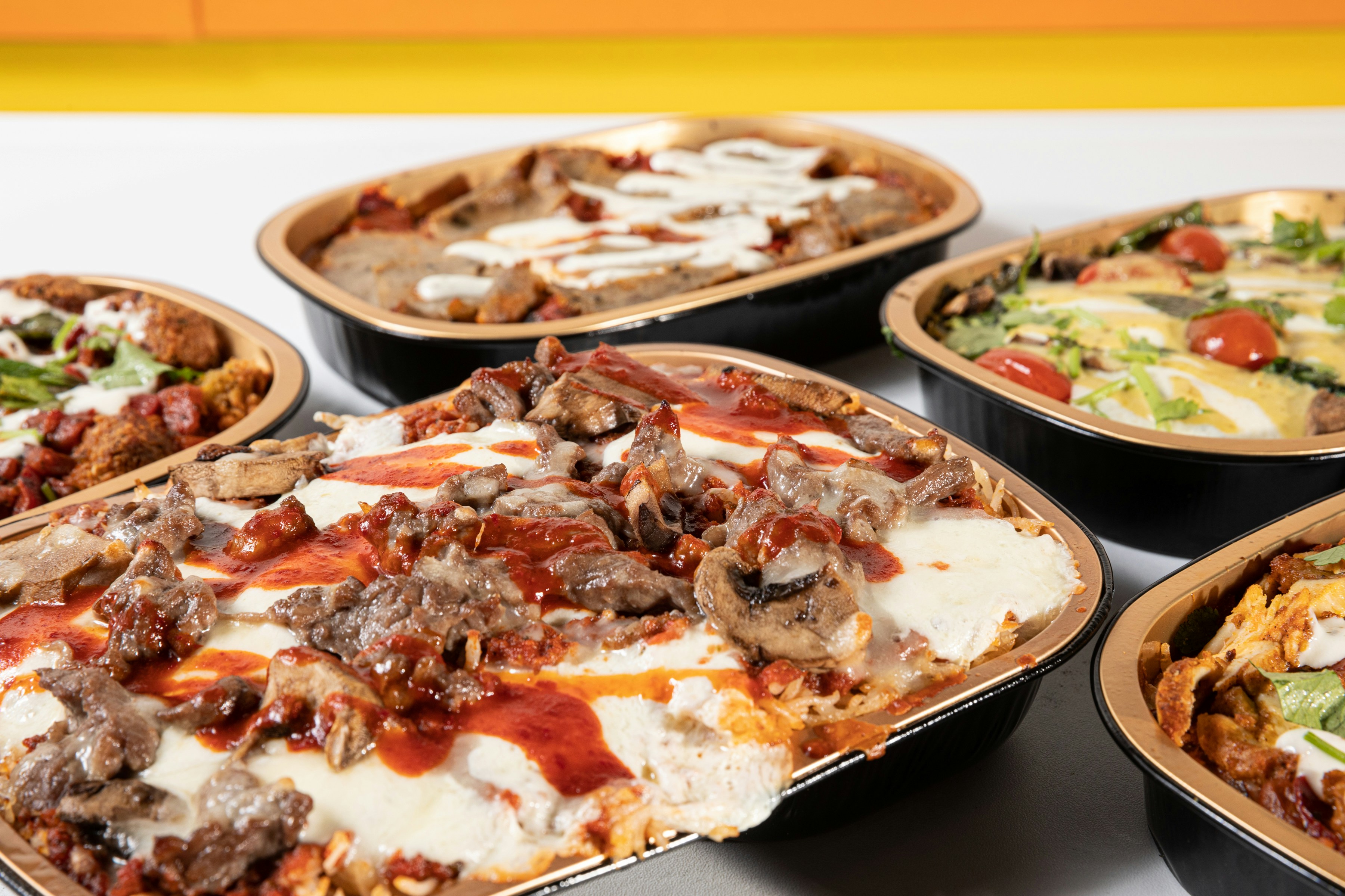 A table topped with lots of different types of pizza