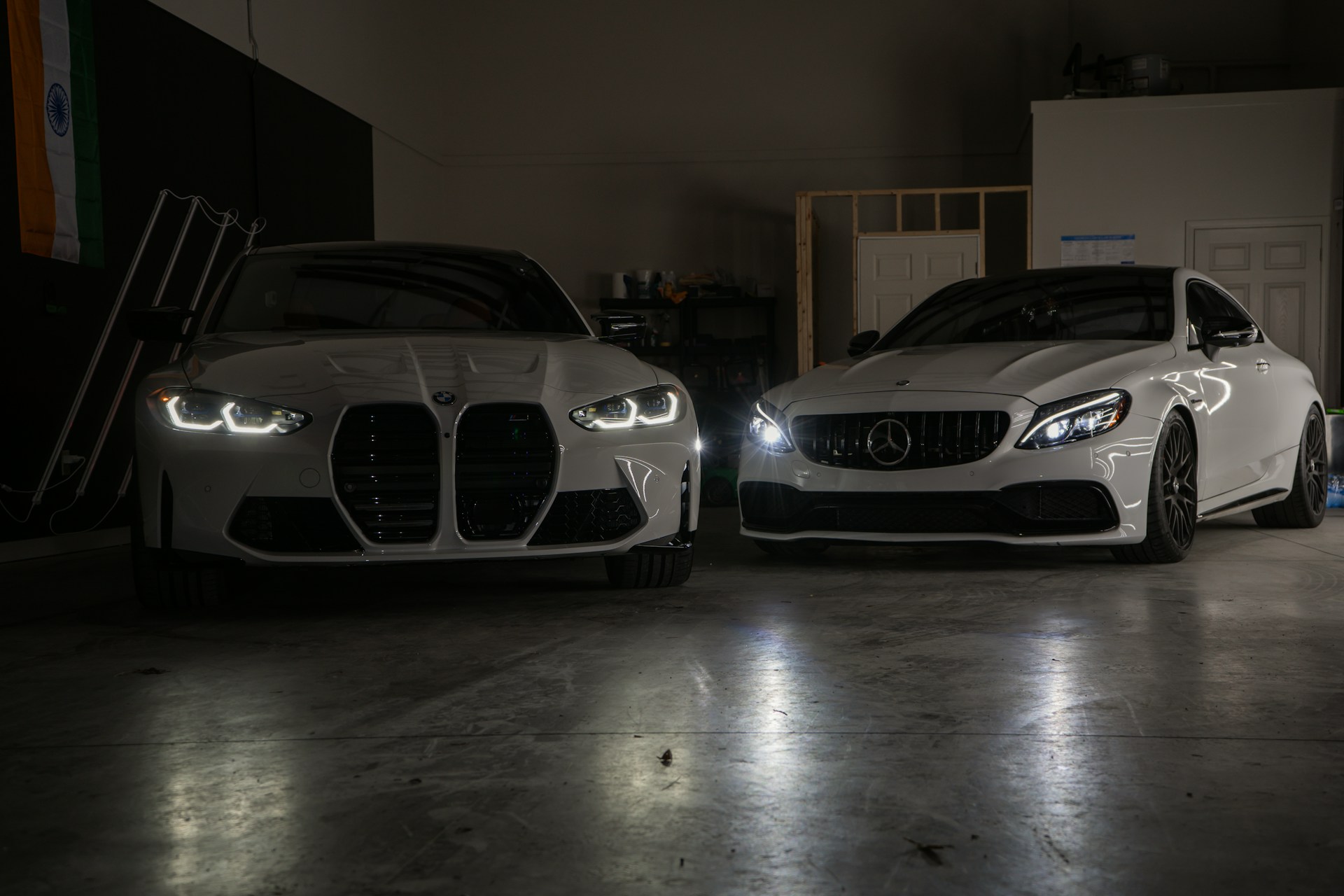 A couple of white cars parked in a garage
