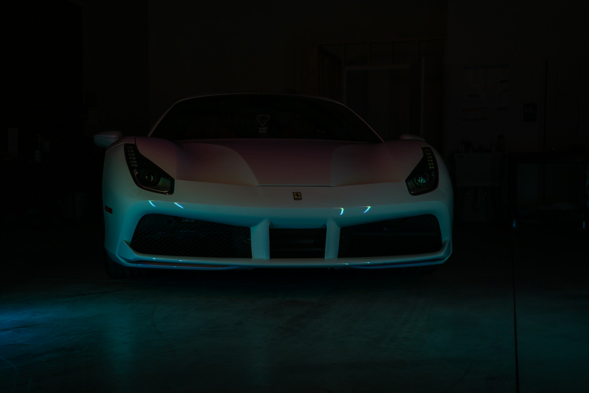 A white sports car parked in a dark garage