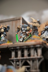 A group of warhammers on a table with a building in the background