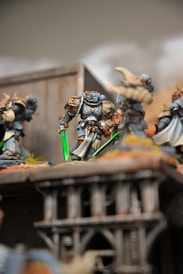 A group of warhammers on a table with a building in the background